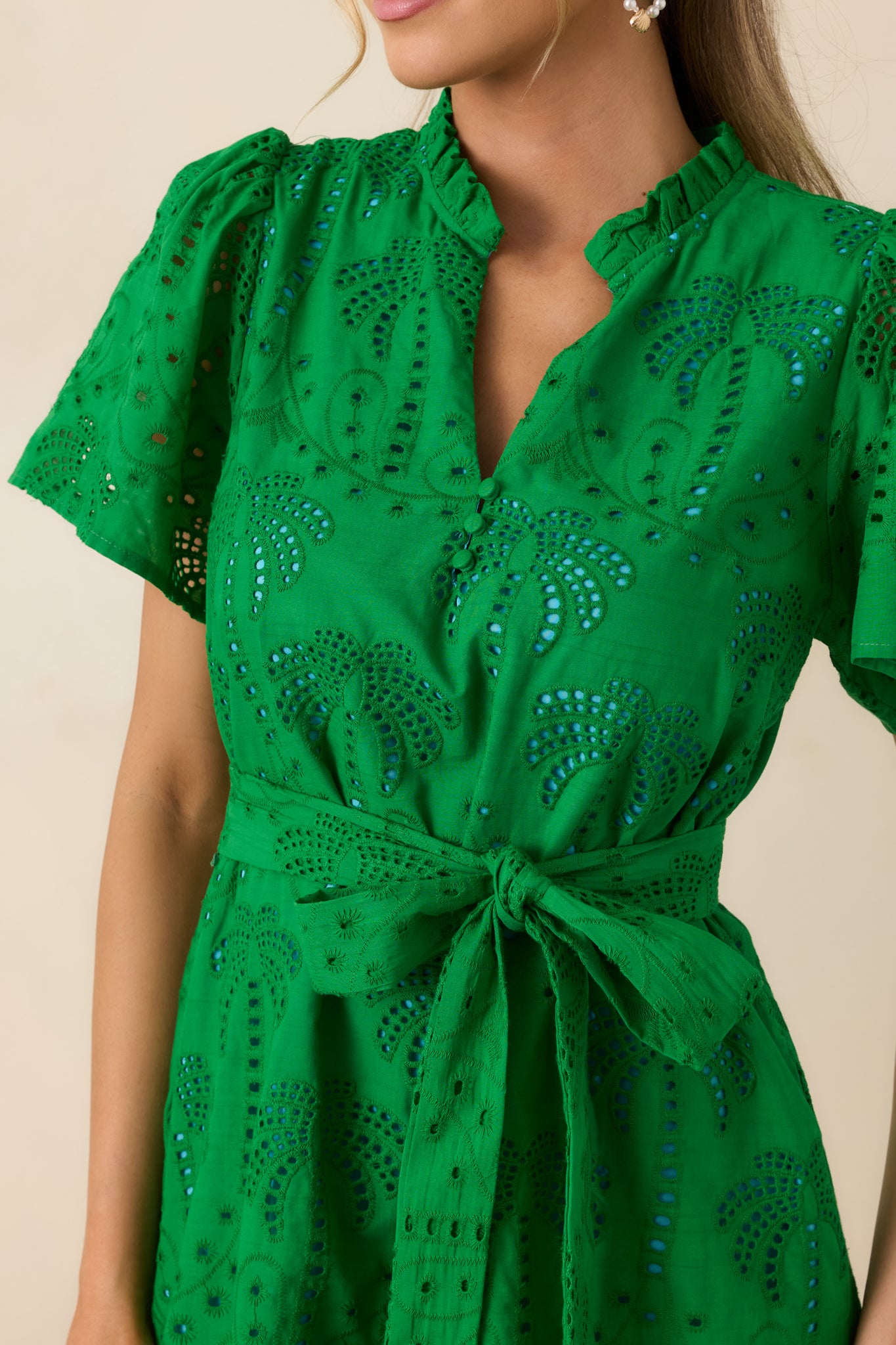 Eyelet pattern with sky blue lining and stitched button detail at neckline.