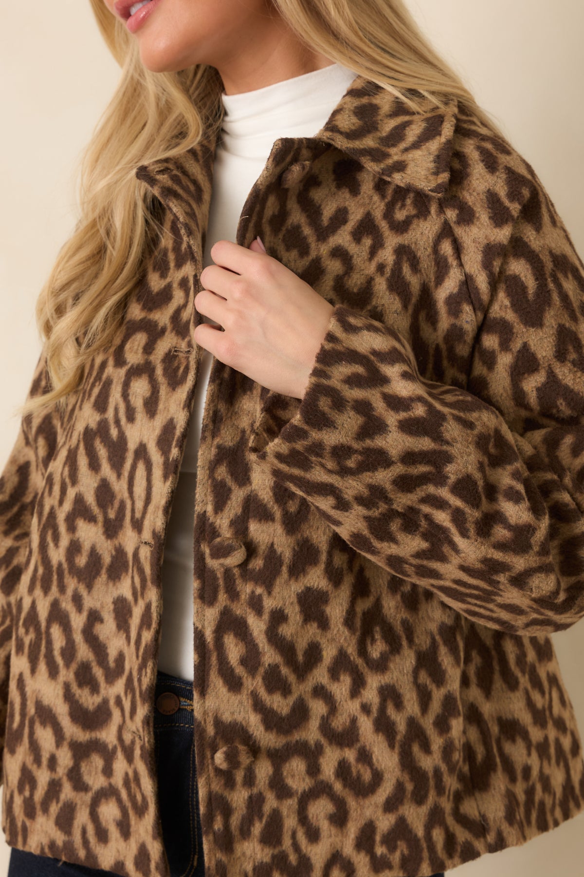 Fabric-covered buttons, spread collar, and dark brown leopard spots showcase the jacket's detailed finish.