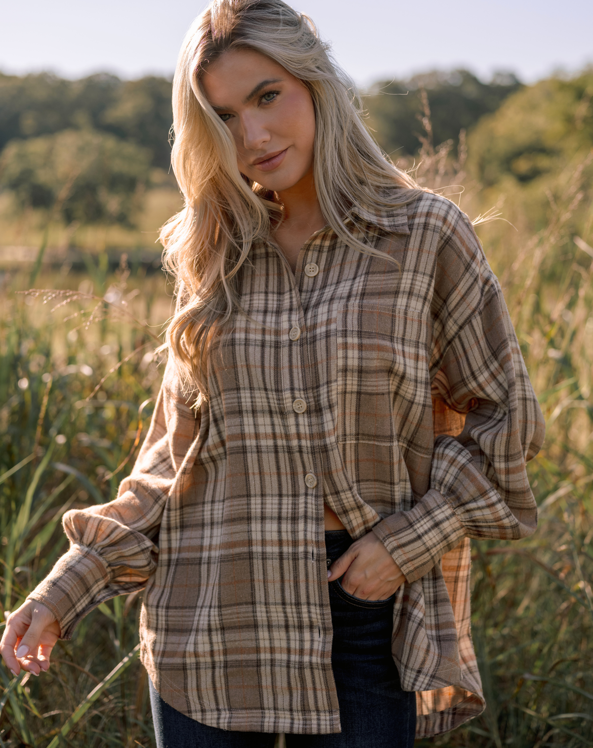Model wearing a tan plaid button down top.
