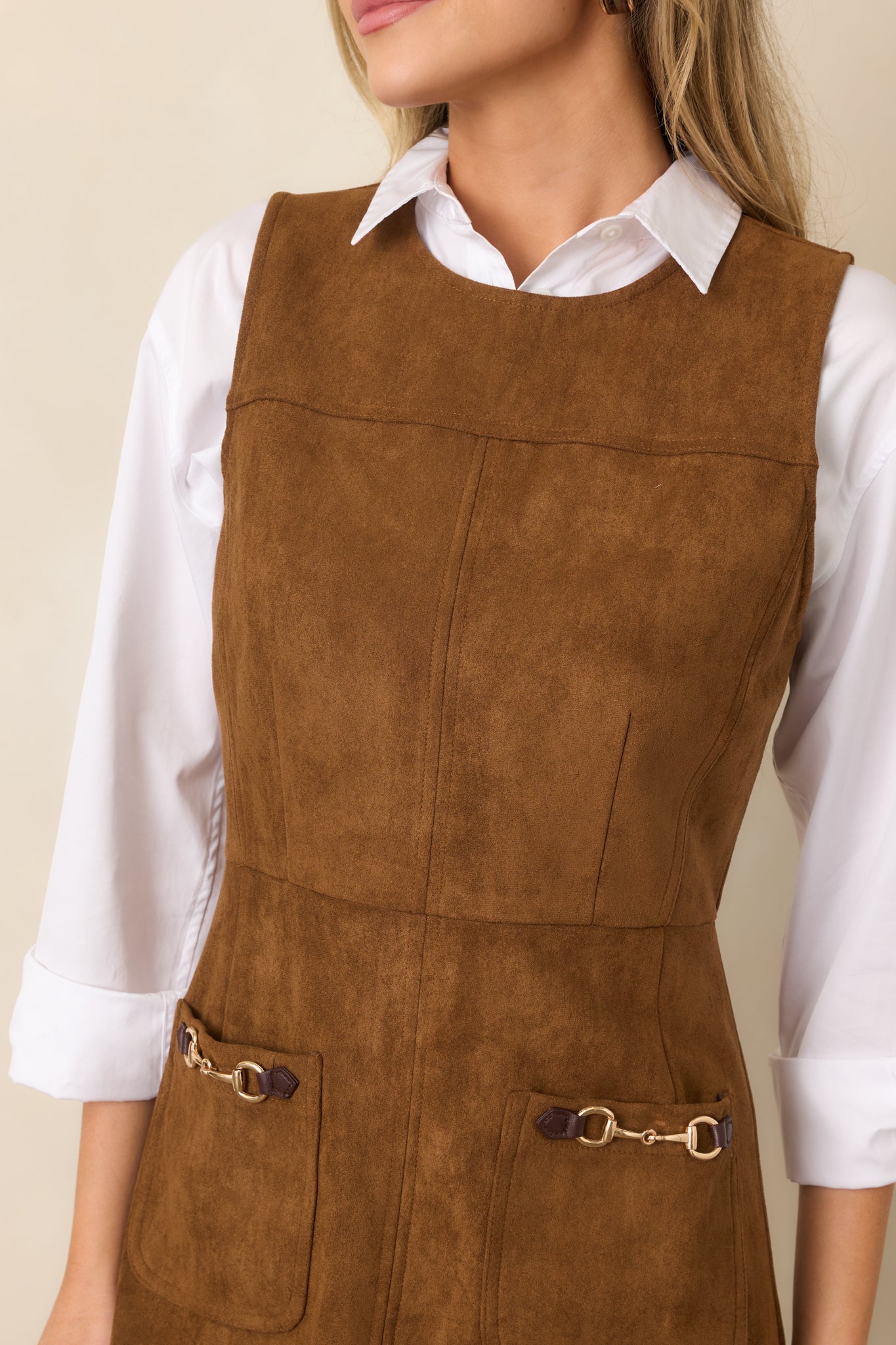 Close-up detail of the faux suede mini dress highlighting the front patch pocket and gold-tone horsebit-inspired hardware.