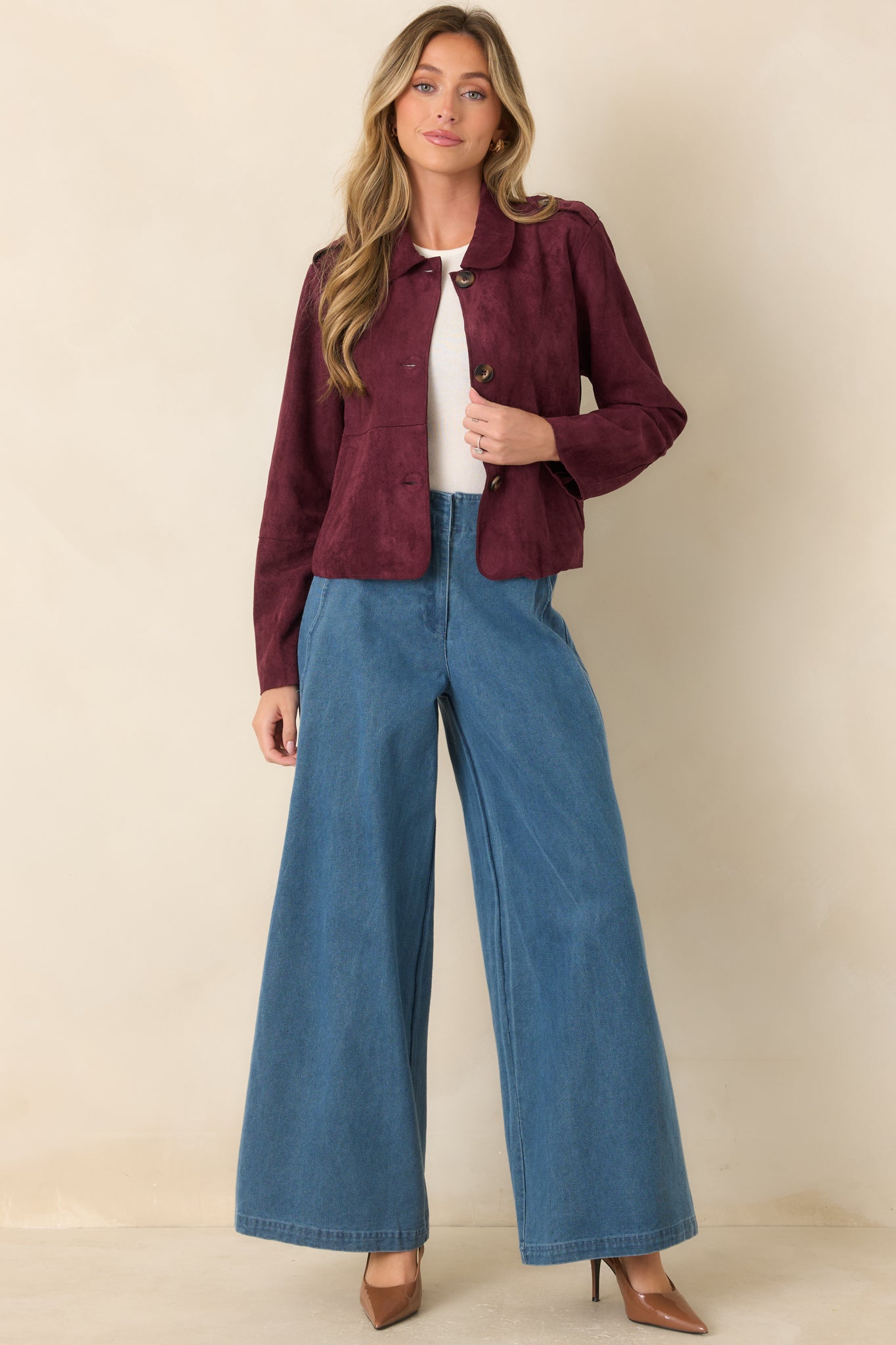 Faux suede jacket with a softly shaped cropped silhouette, rounded collar, functional front buttons, and large patch pockets for timeless versatility.