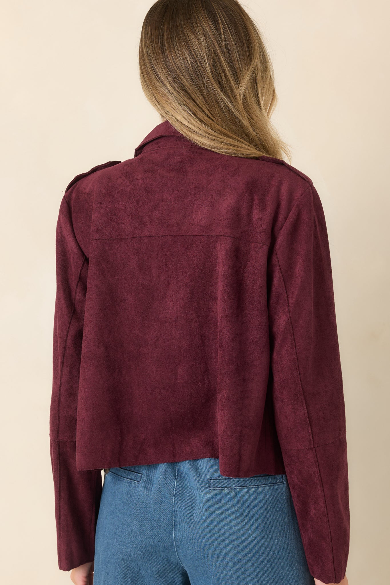 Rear view of the cropped faux suede jacket featuring a clean back, long sleeves, and a softly shaped silhouette with tailored-inspired structure.