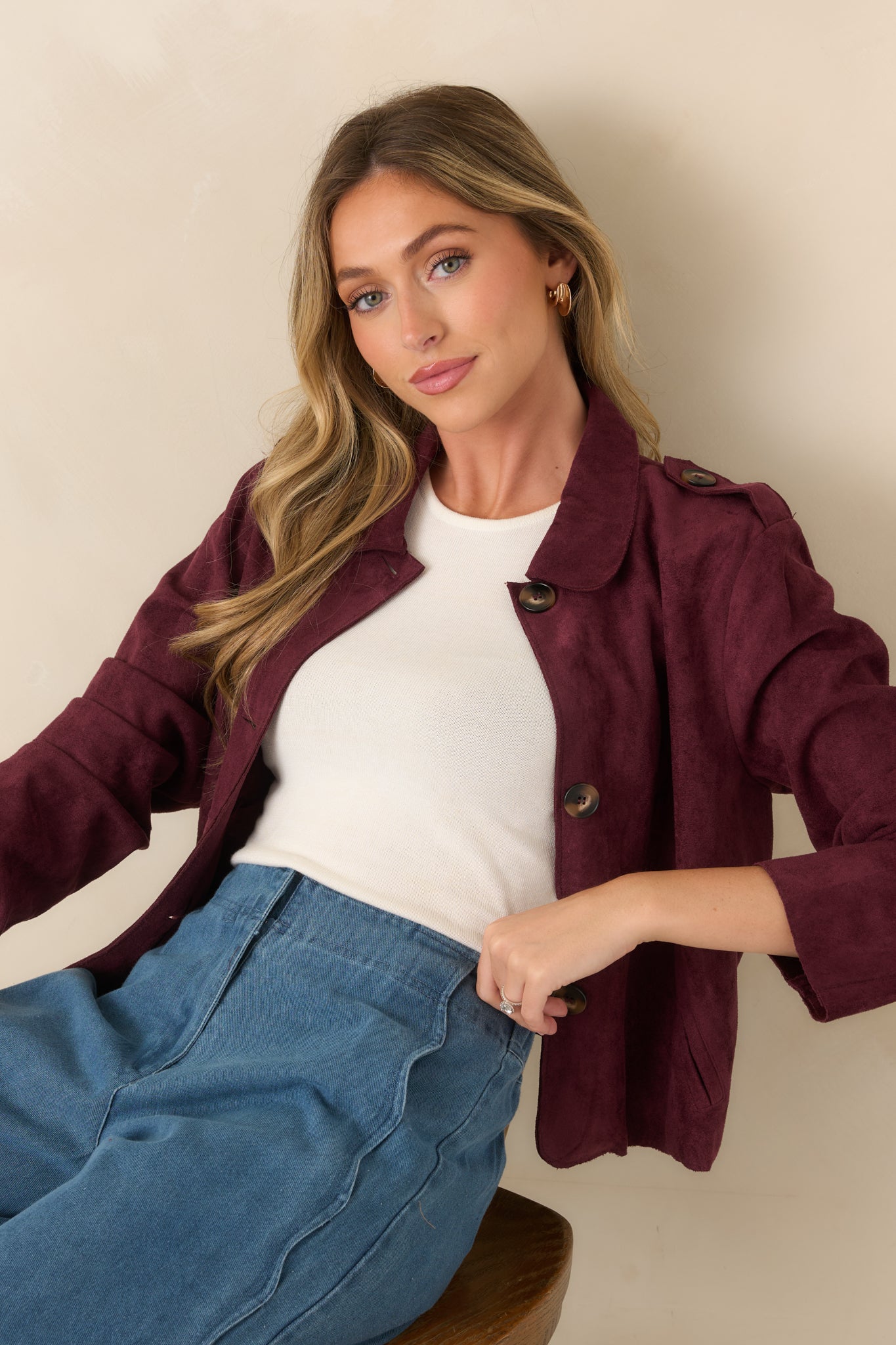 Faux suede jacket featuring large front patch pockets, subtle shoulder tabs, and a clean button-front design with refined tailoring.