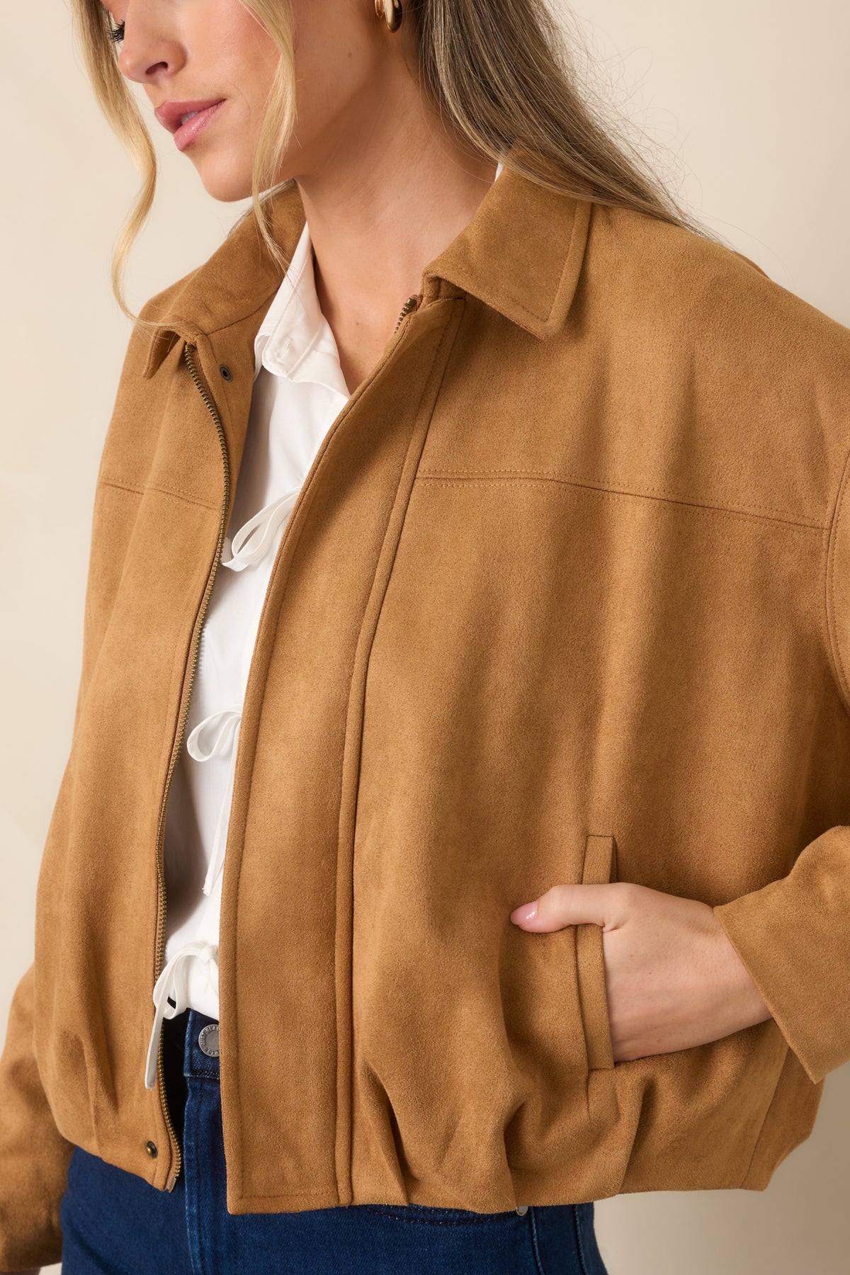 Close-up of the faux suede jacket highlighting the soft textured finish, precise seam detailing, and concealed zipper beneath the front placket.