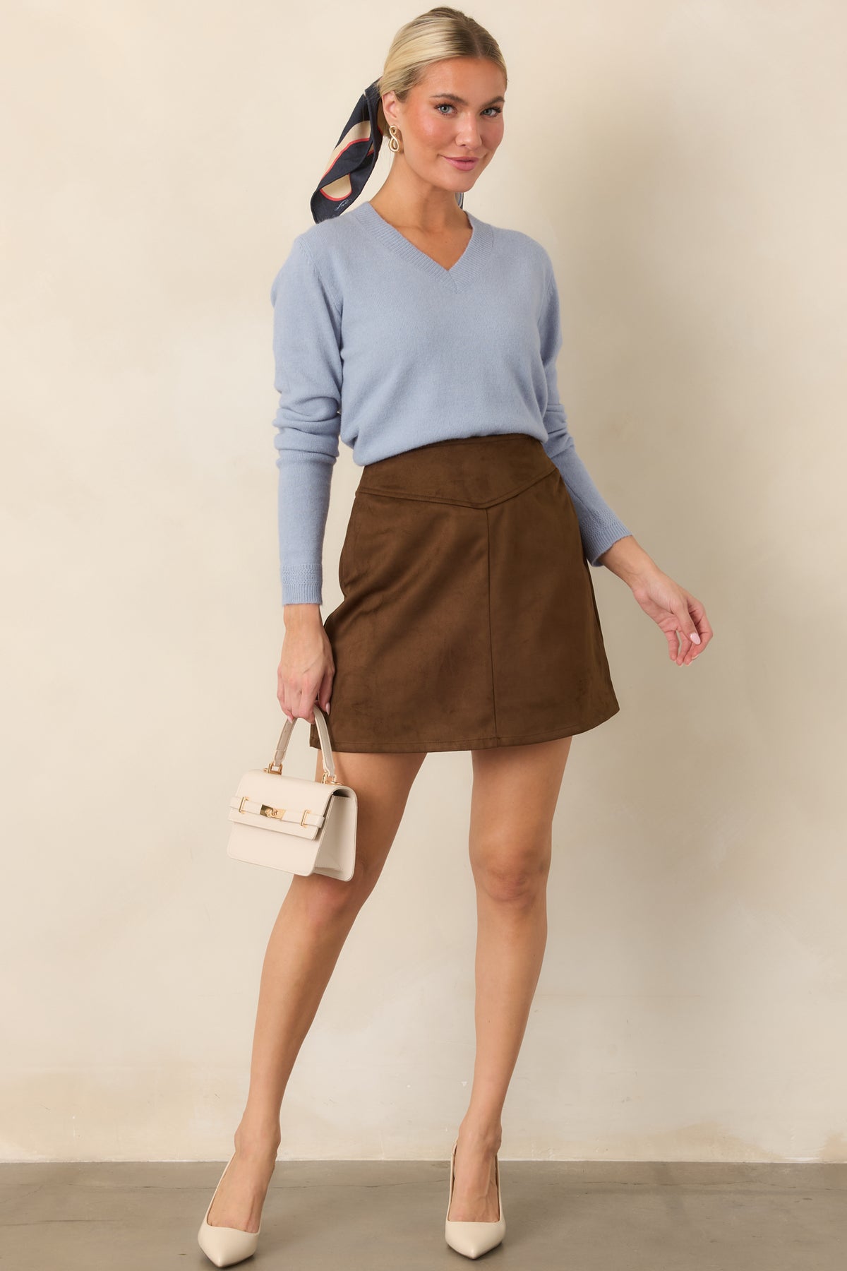 Faux suede mini skirt showcasing the center front seam and polished flared shape.