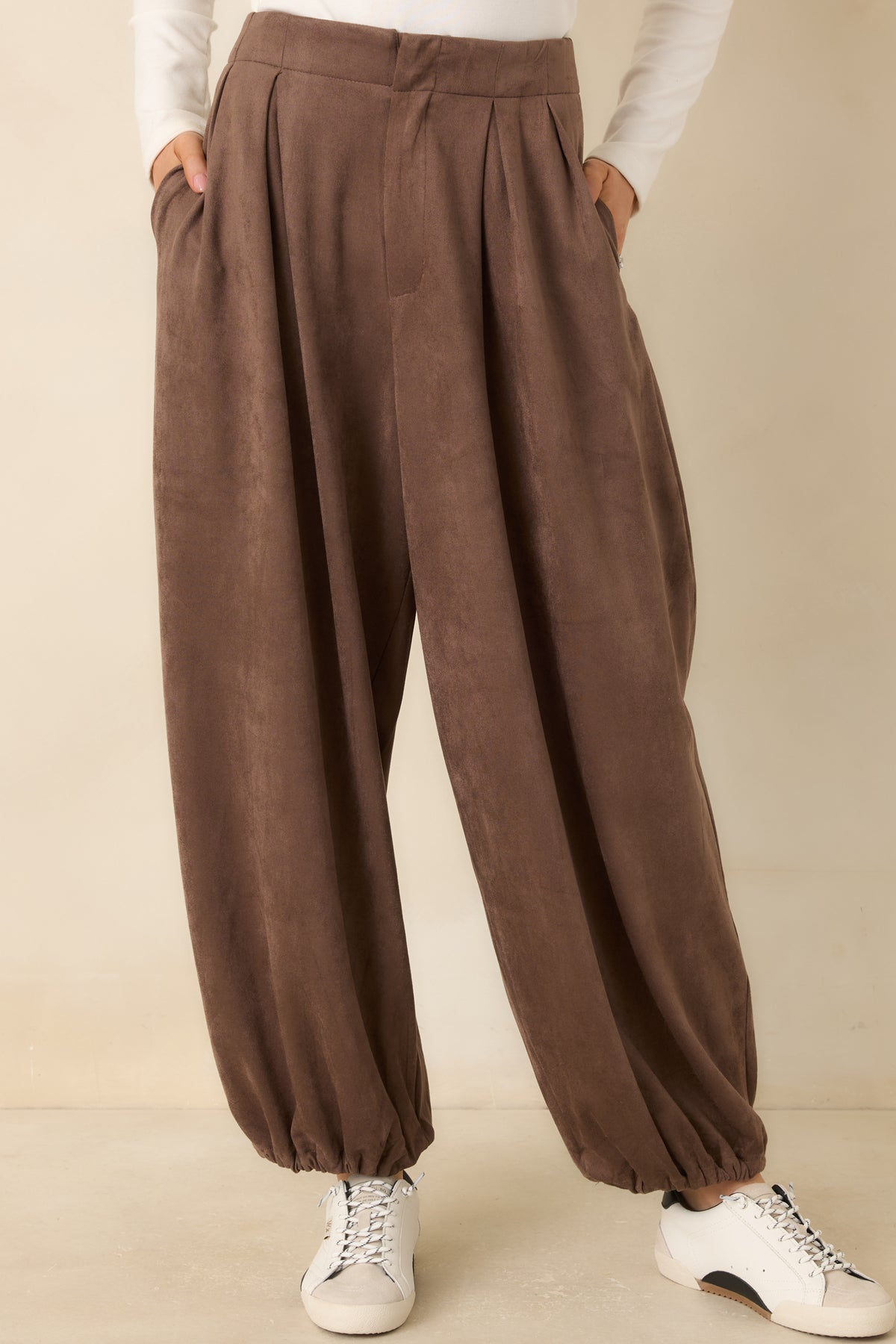 Front pleats add volume to the soft faux suede pants below the flat waistband.