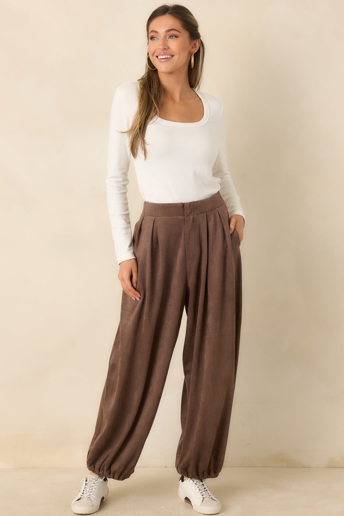 Faux suede pants with a fluid drape, functional side pockets, and gathered cuffs.