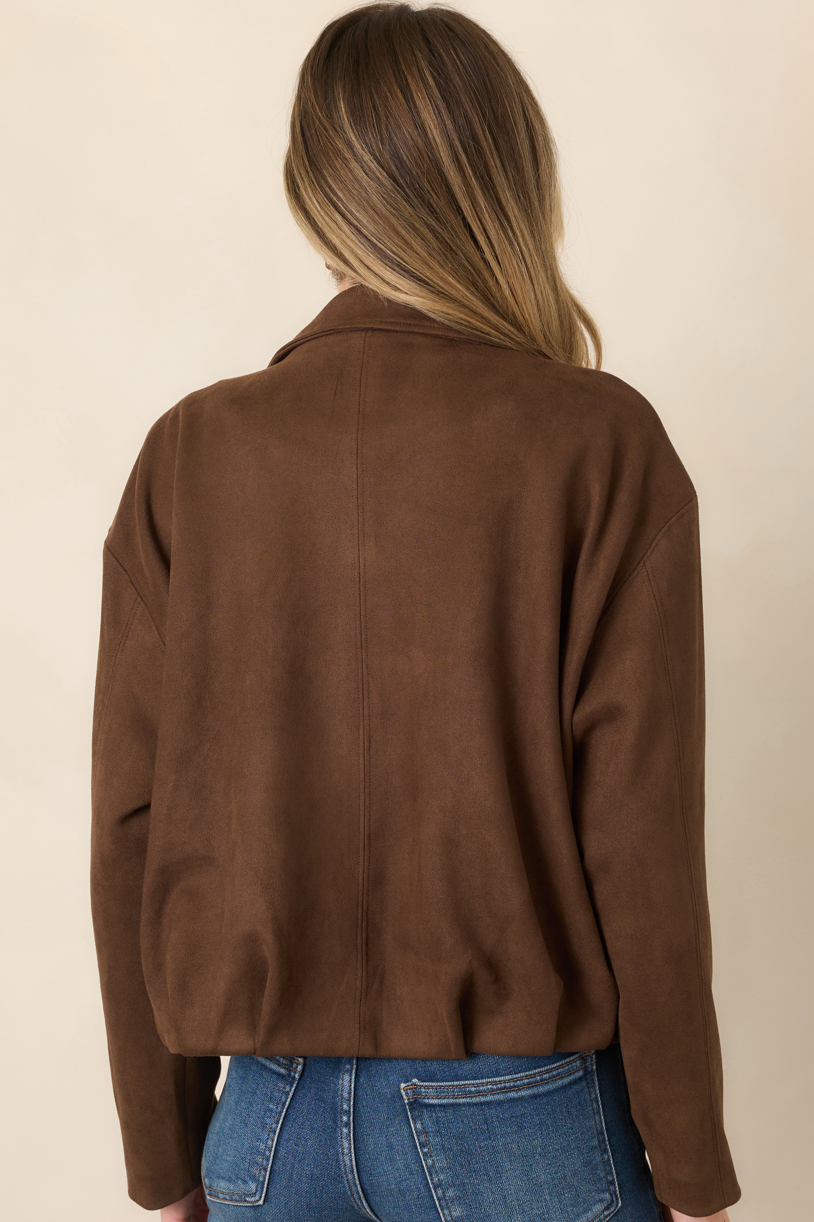 Rear view of the faux suede jacket showing the dropped shoulders, relaxed blouson shape, subtle seam detailing, and gathered hem.