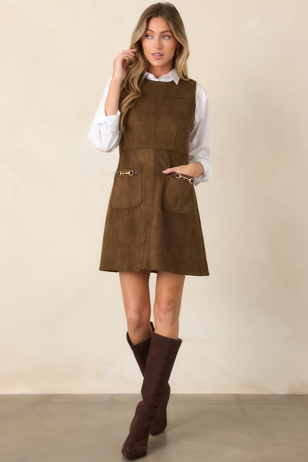 Refined faux suede mini dress designed with a streamlined bodice, structured panel seams, fitted waist, and softly flared A-line skirt.