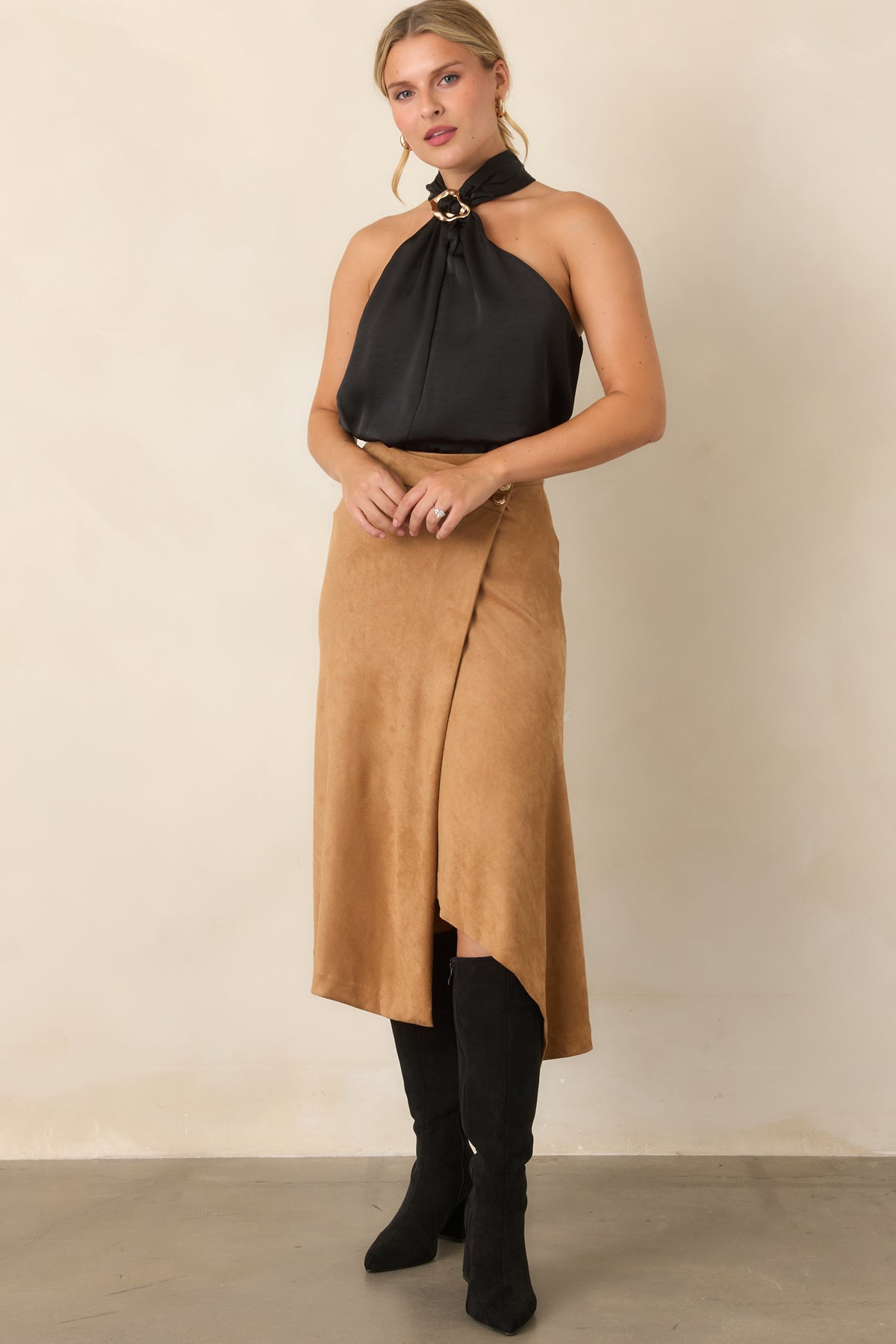 Faux suede skirt with a high-rise waist, asymmetrical wrap front, and angled hem.