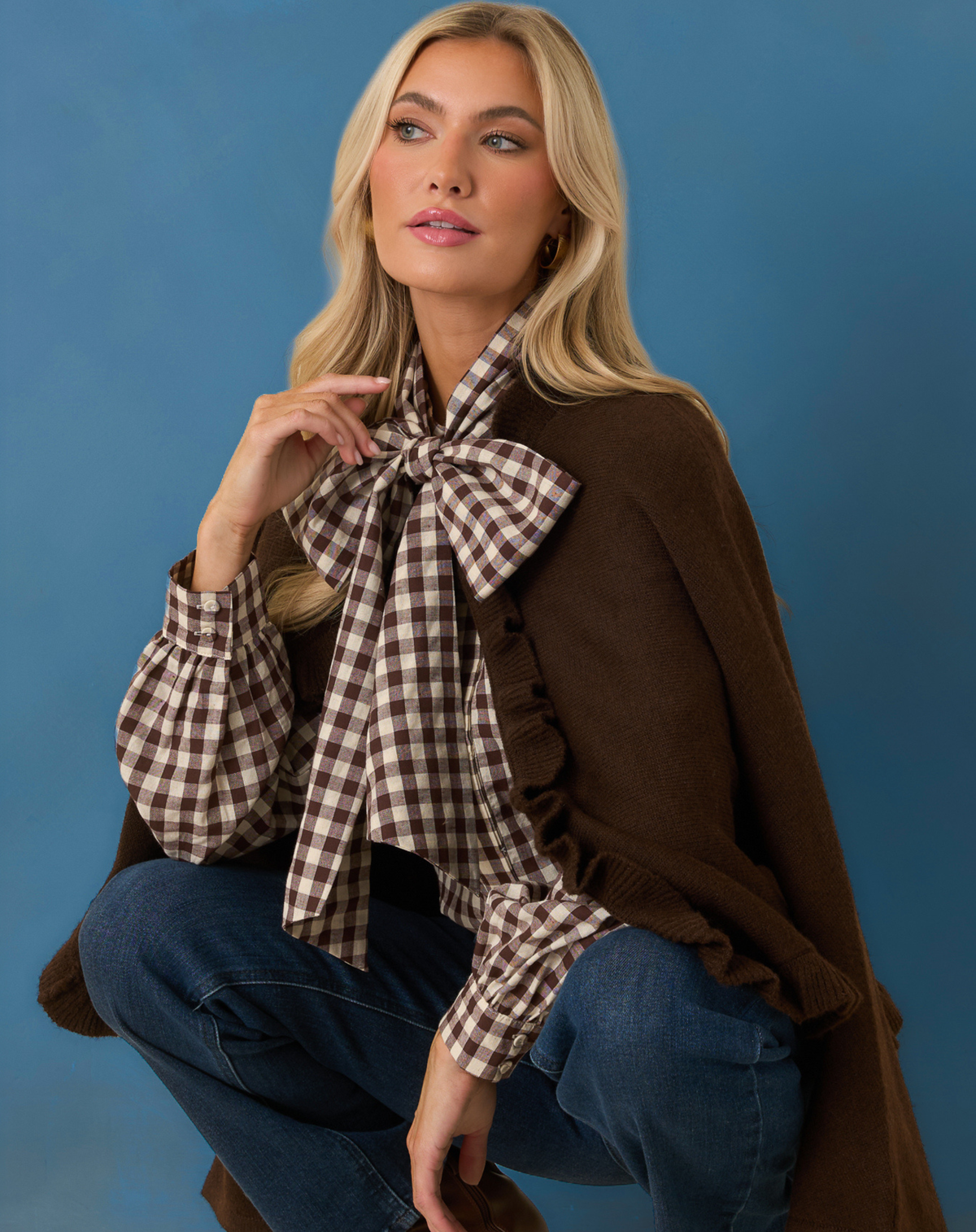 Model wearing a brown gingham shirt and sweater.