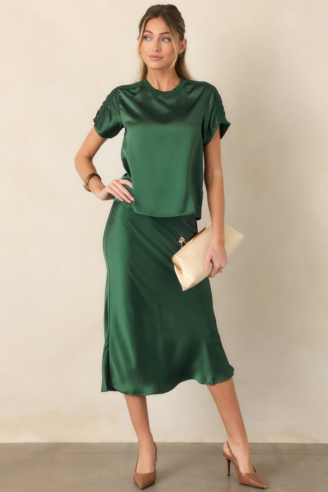 Feminine satin midi skirt with a lustrous finish, comfortable elastic waist, smooth hip-skimming shape, and softly flowing lower silhouette.