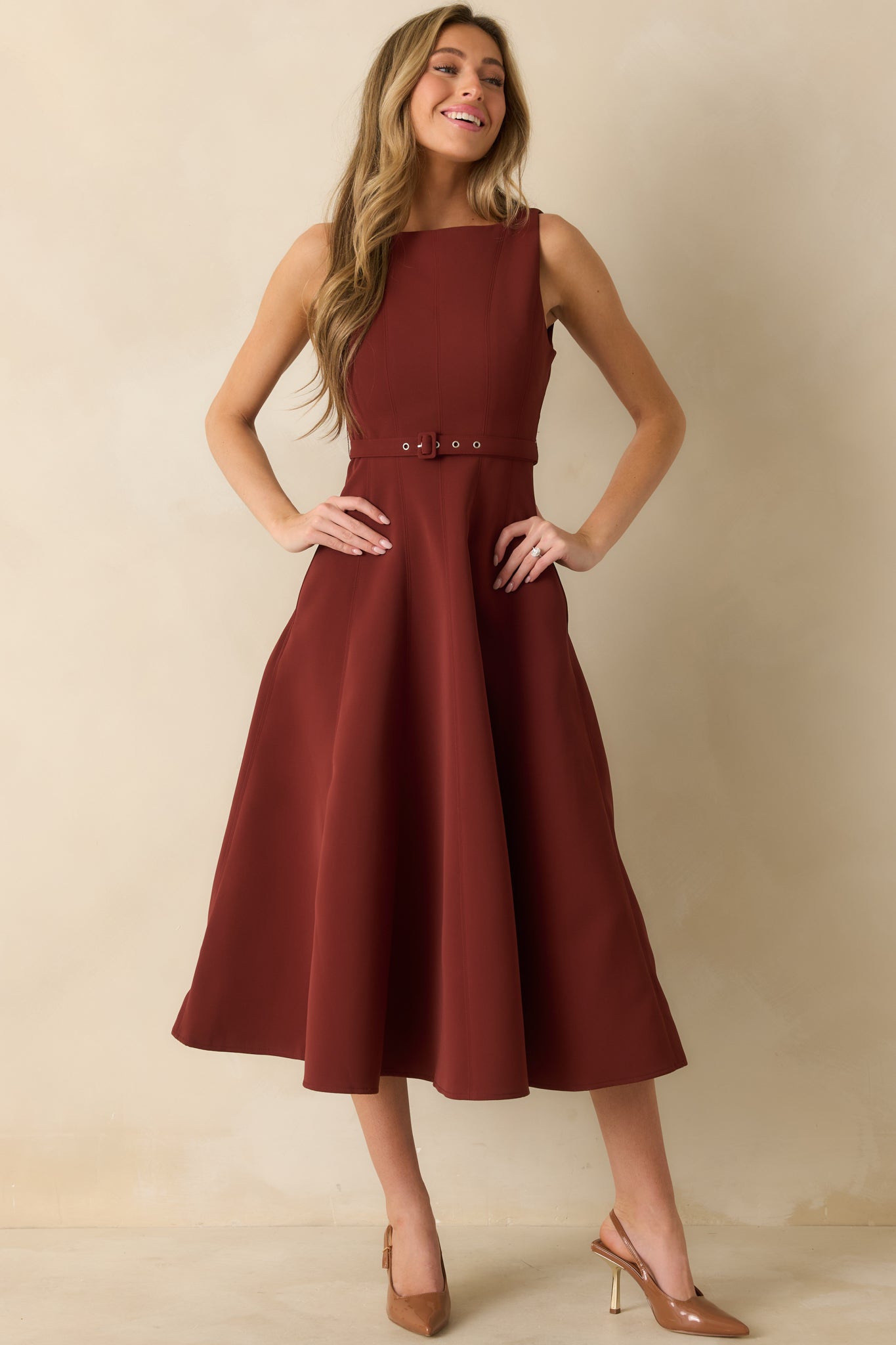 Fitted bodice and flared skirt on wine red midi dress with sleek waist belt.