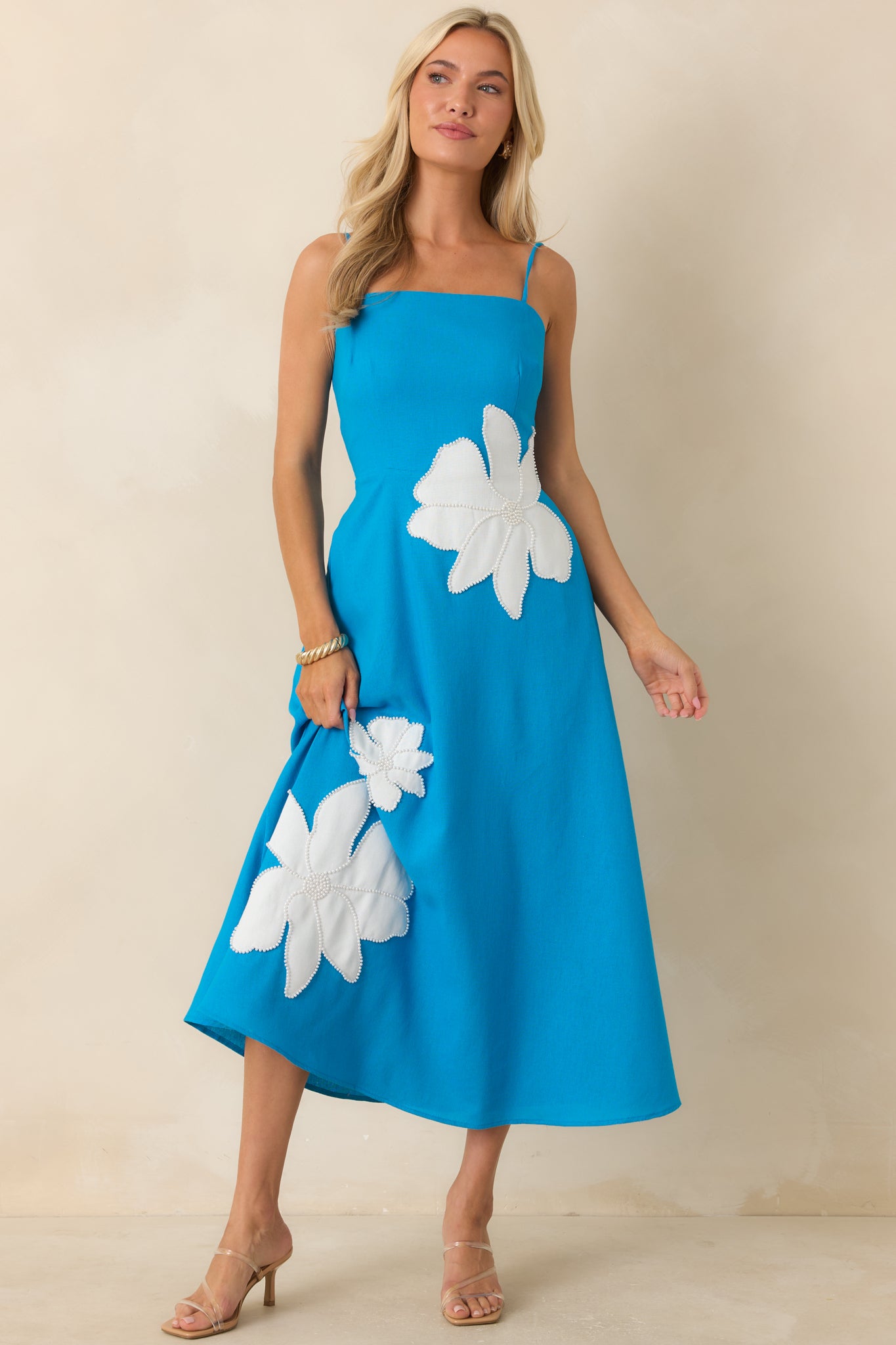 Linen-blend midi dress featuring a fitted bodice, adjustable shoulder straps, side pockets, and a flowing A-line skirt.
