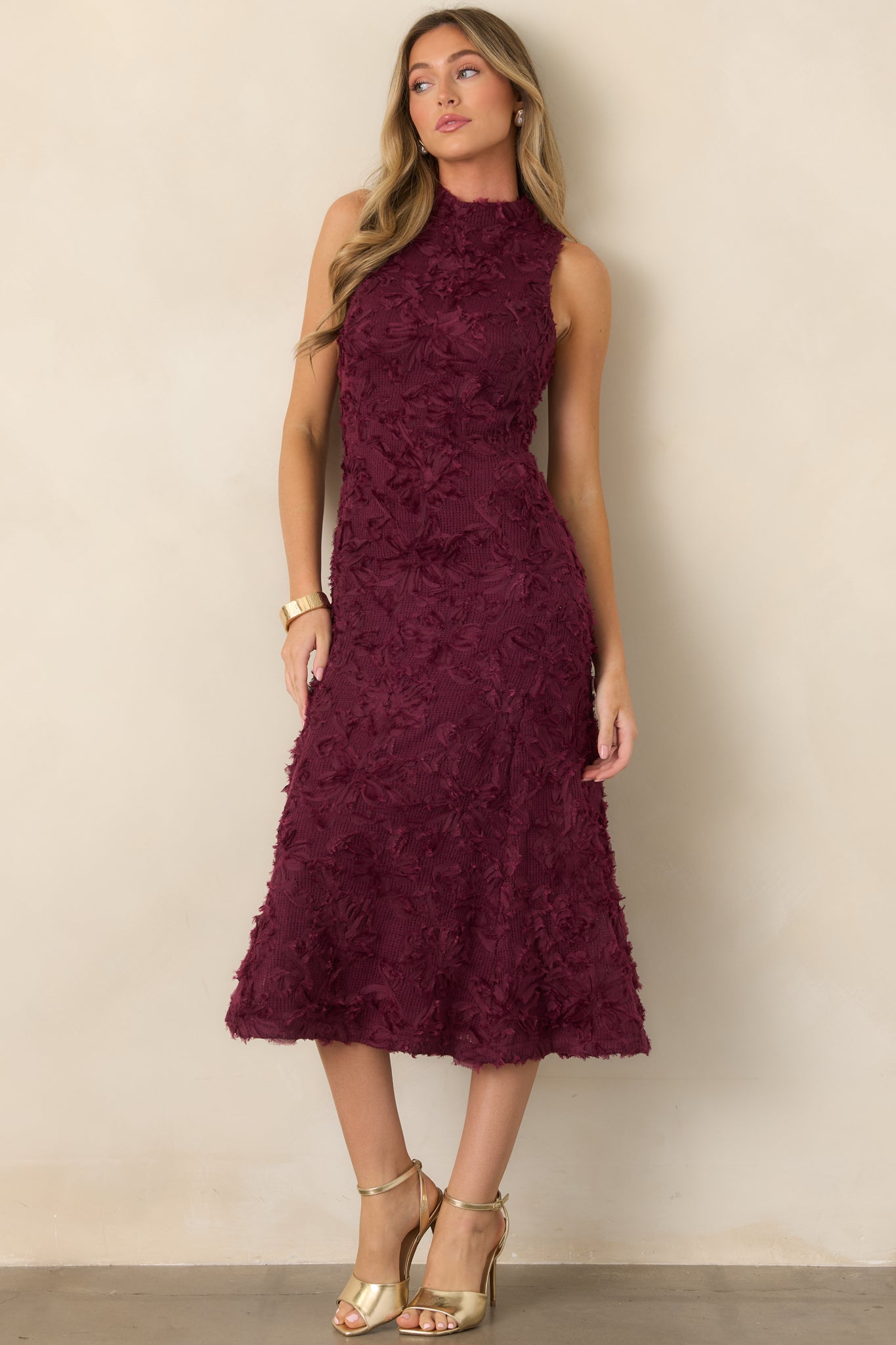 Floral appliqué midi dress showcasing its fitted upper silhouette, sleeveless high-neck design, richly textured knit construction, and softly widening skirt.