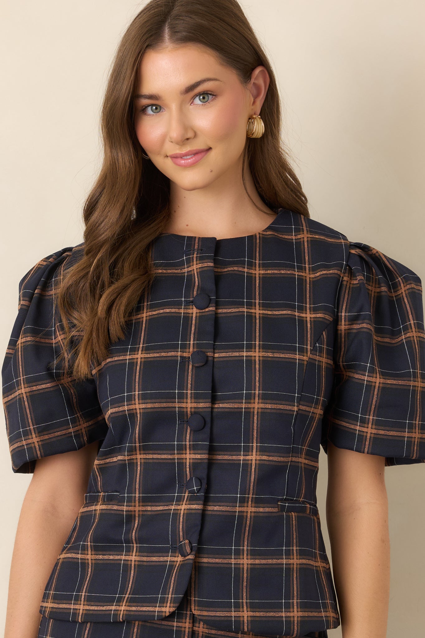 Close view of the fitted plaid bodice, featuring tailored seams and a structured woven texture in navy, camel, and ivory.