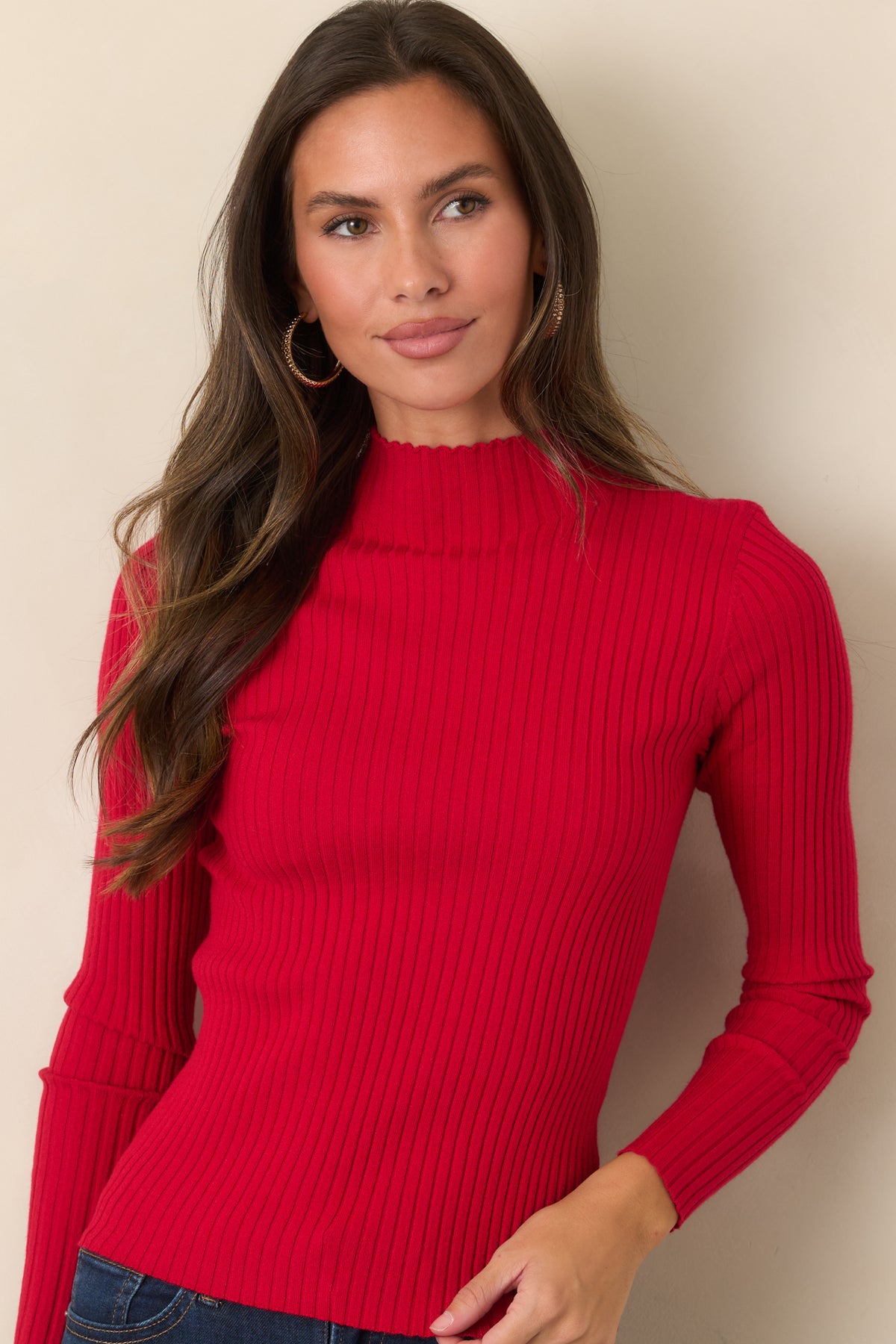Fitted ribbed knit top featuring delicate ruffle accents along the long sleeves.