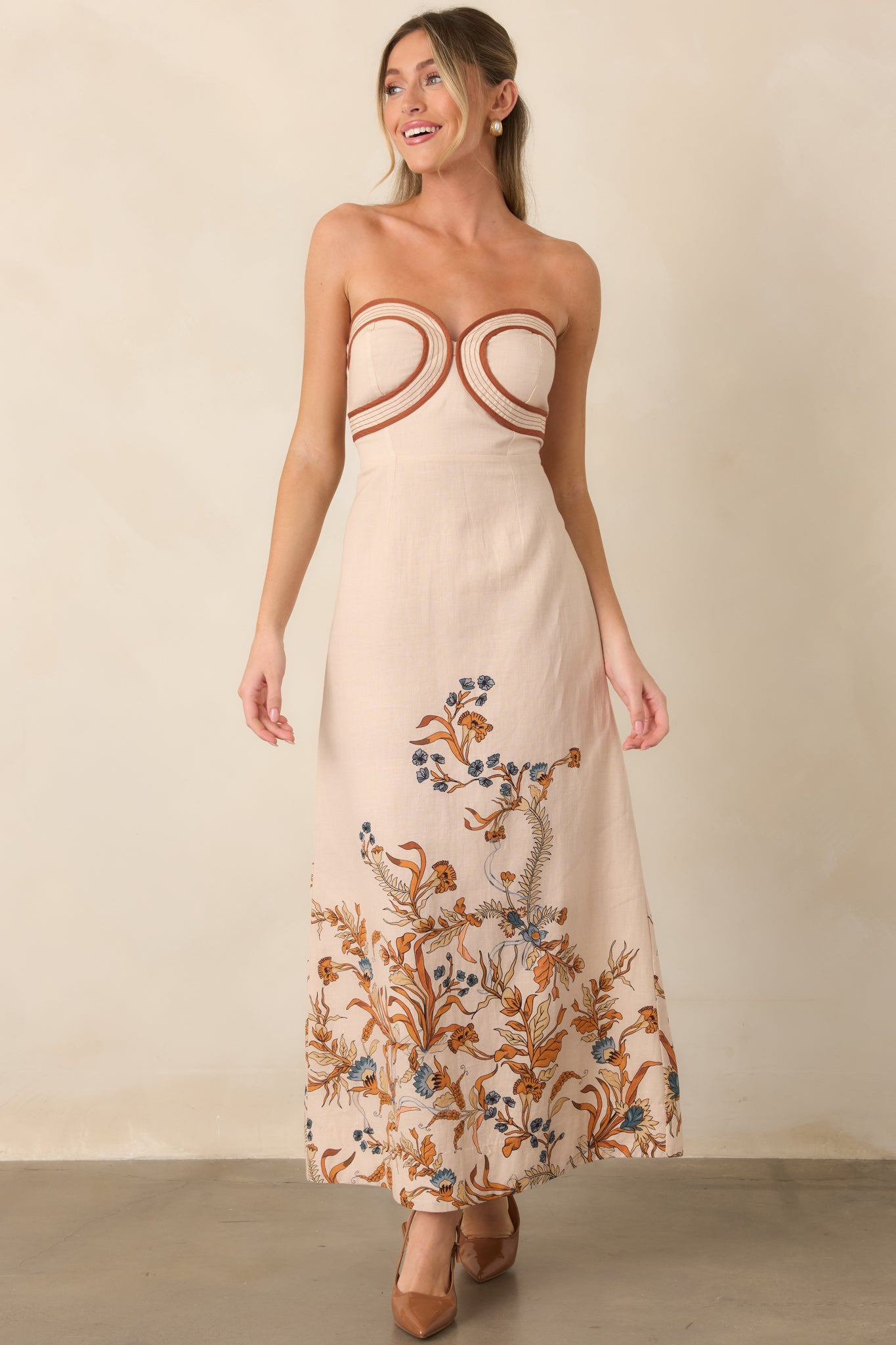 Fitted strapless dress with a smooth cotton-lined interior, sculpted bodice, and softly contrasting floral border along the skirt hem.