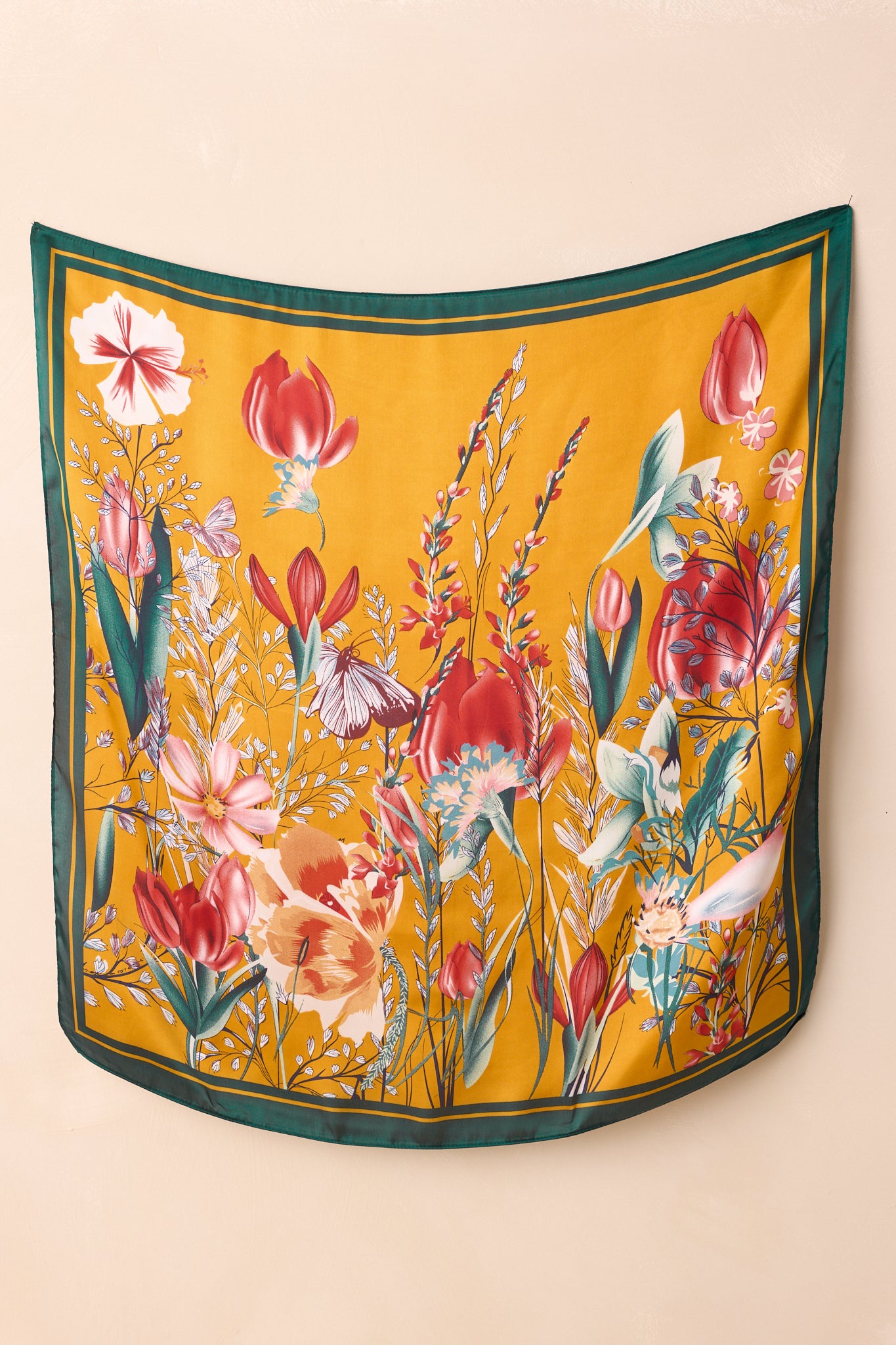 The green floral scarf displayed flat, showing vibrant blooms and matching green edging.