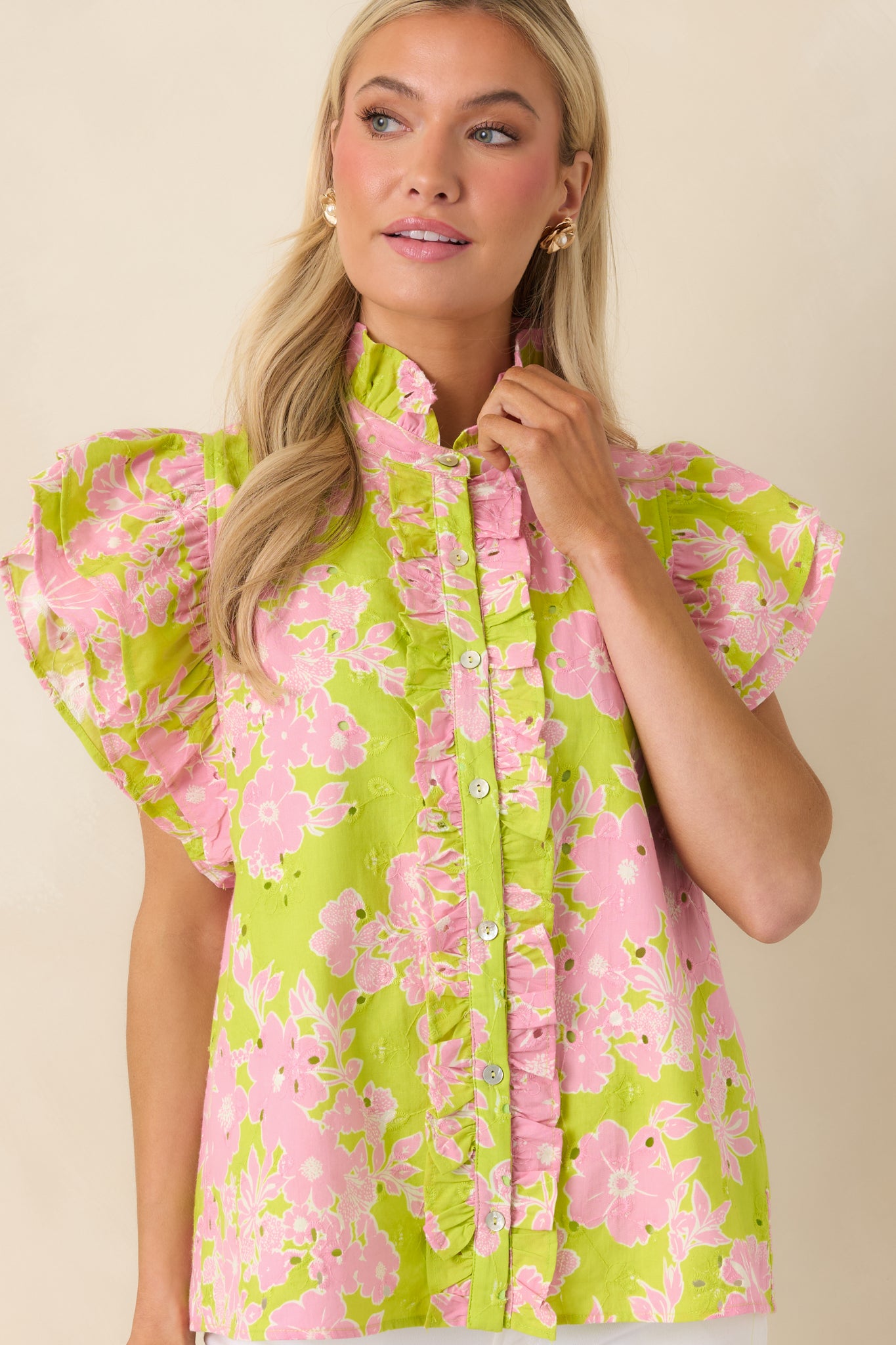 Floral blouse highlighting ruffle trim along button front and soft fabric.