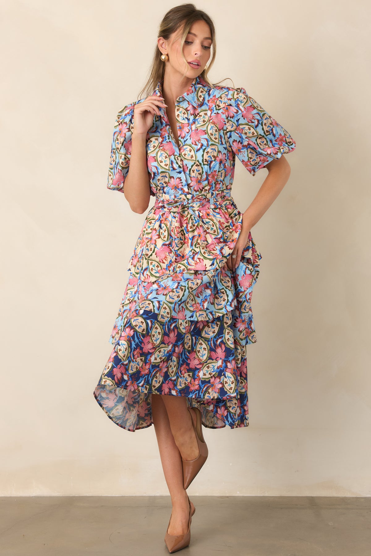 Floral midi dress featuring pink blossoms, curling green vines, cream botanical motifs, and contrasting blue and ivory backgrounds.