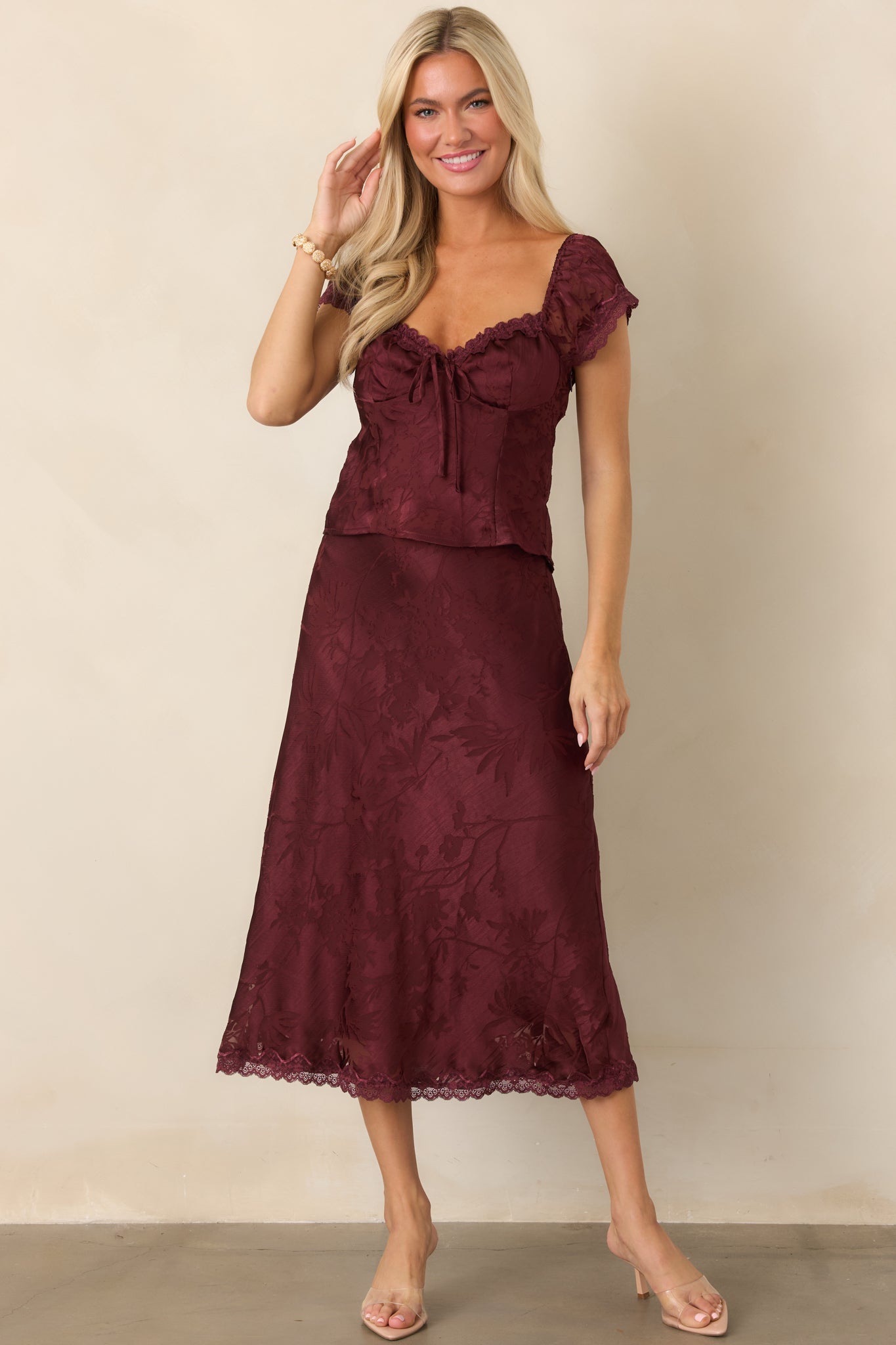 Feminine floral burnout blouse showcasing its lace-trimmed sweetheart neckline, elasticized cap sleeves, fitted silhouette, and softly dimensional texture.