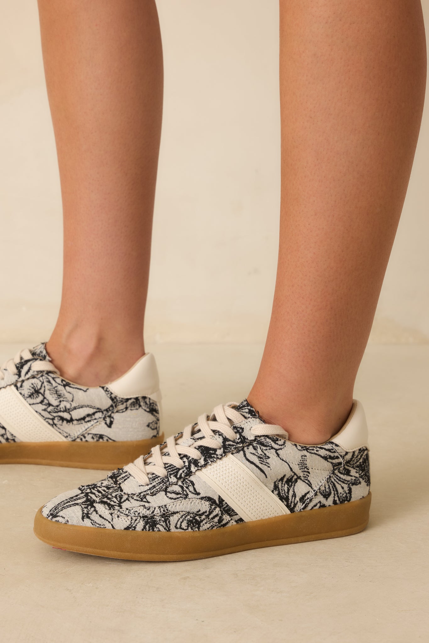 Close-up of the floral canvas pattern, cream leather accents, and stitching details.