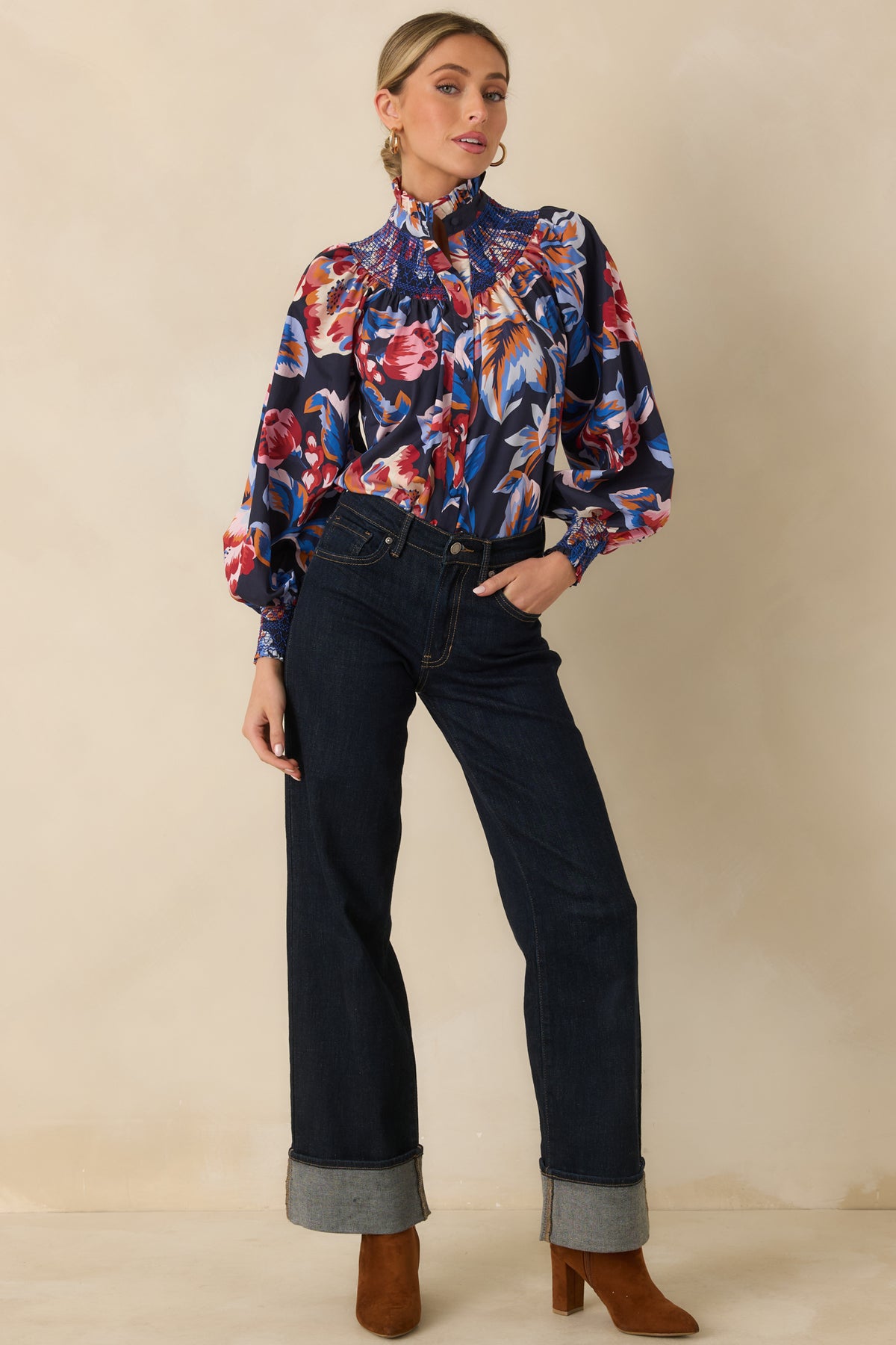 Floral cotton top featuring intricate blue smocking across the front yoke, fabric-covered buttons, and softly gathered sleeves.