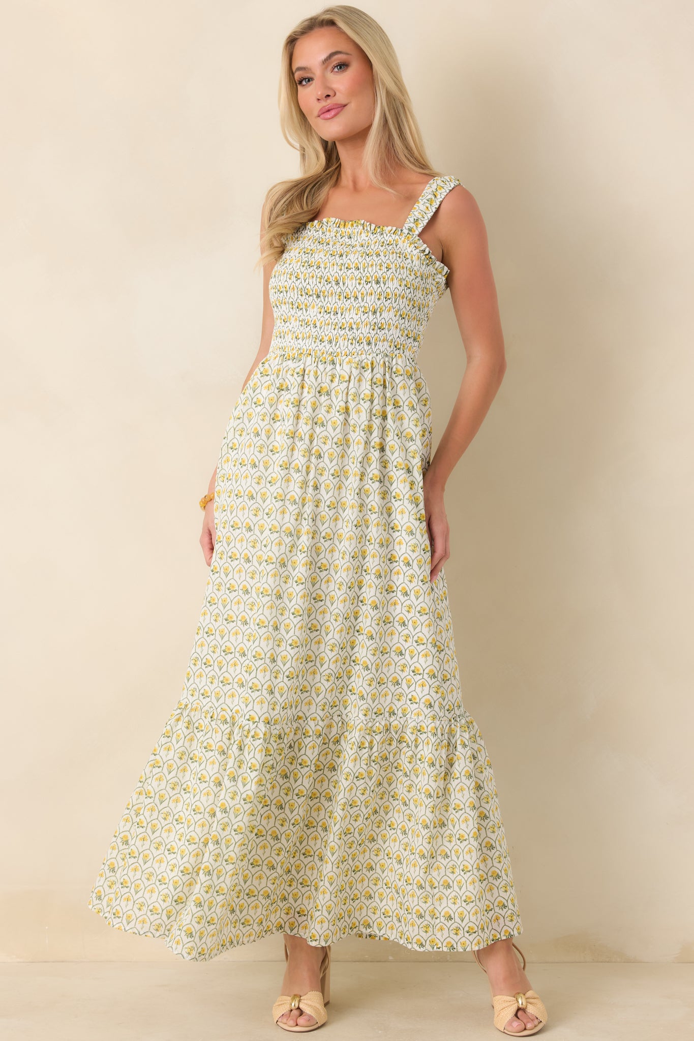 Floral print cotton maxi dress in yellow tones featuring a stretchy smocked bodice, structured square neckline, and tiered skirt with soft volume.