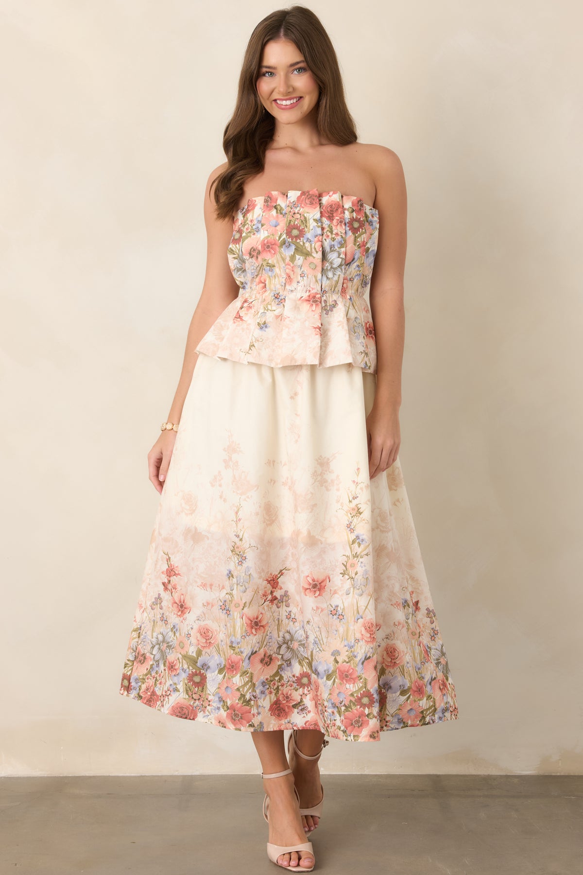 Floral cotton midi dress showcasing its strapless neckline, structured pleated bodice, defined elasticized waist, and feminine skirt silhouette.