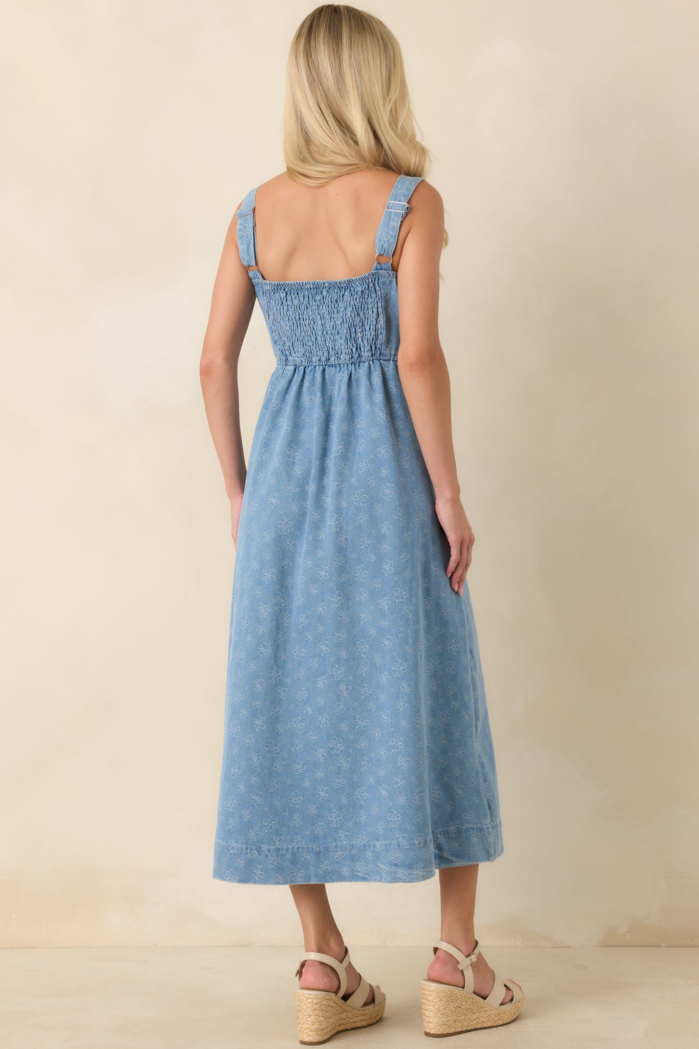 Back view of the floral dress featuring a smocked back panel and adjustable straps.