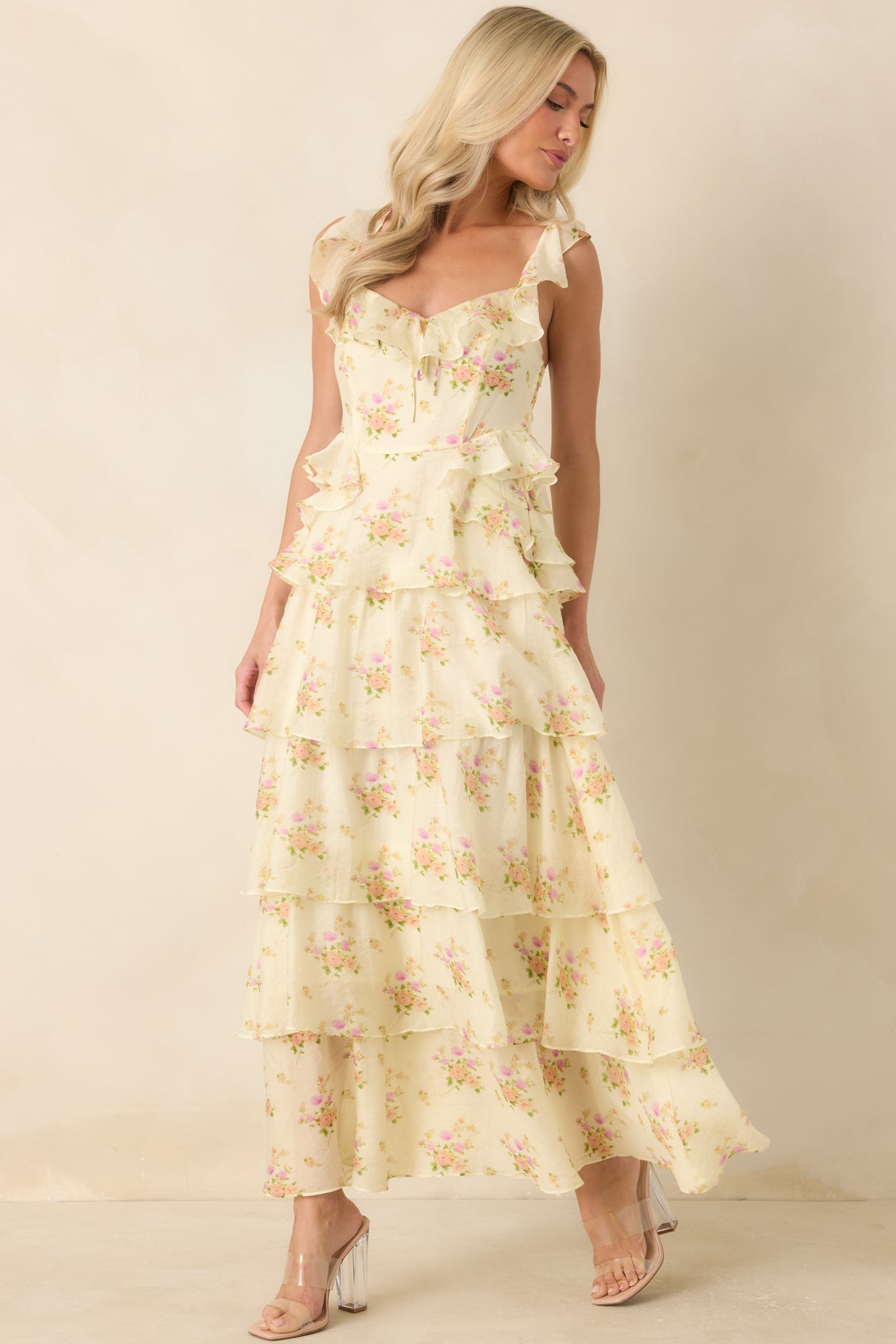 Feminine floral dress featuring a self-tie neckline bow, ruffled details, and a flowing tiered silhouette.