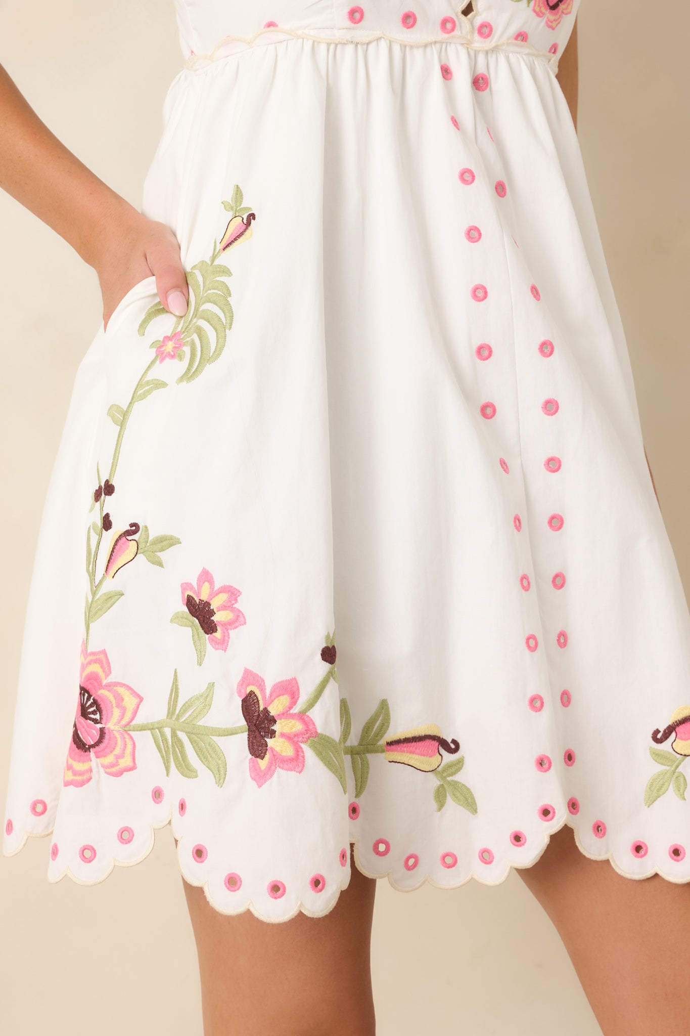 Detailed view of the floral embroidery, scalloped neckline, peek-a-boo button-front detail, and embroidered scalloped hem.