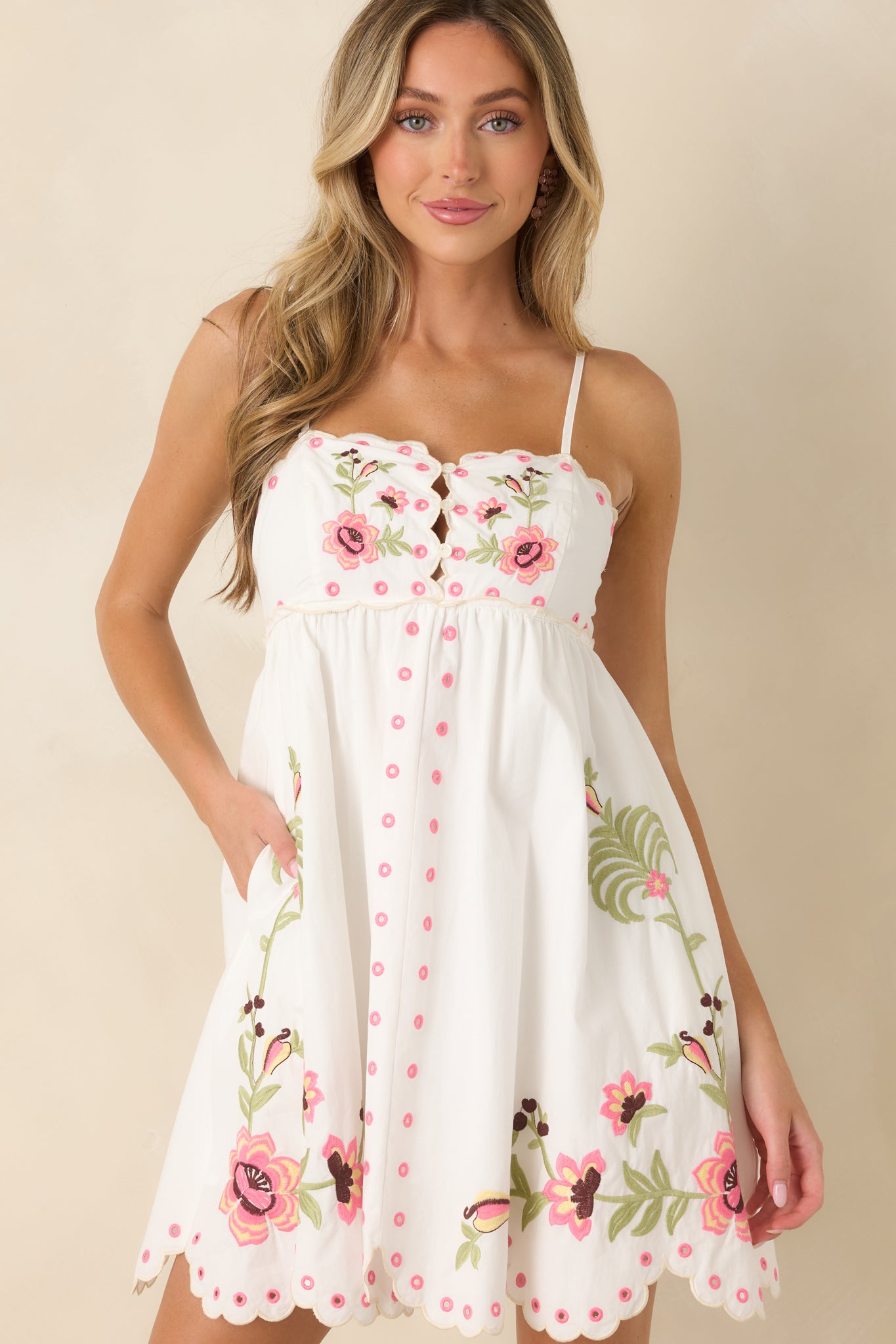 Intricate floral embroidery stands out across the breathable cotton fabric of this feminine mini dress.