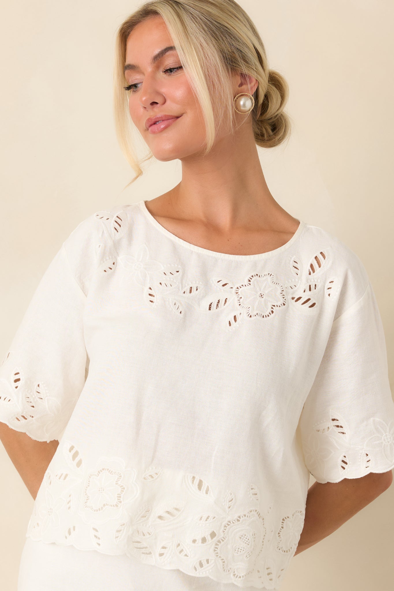 Beautiful floral cutwork embroidery highlights the hem and soft linen-blend fabric of this white top.