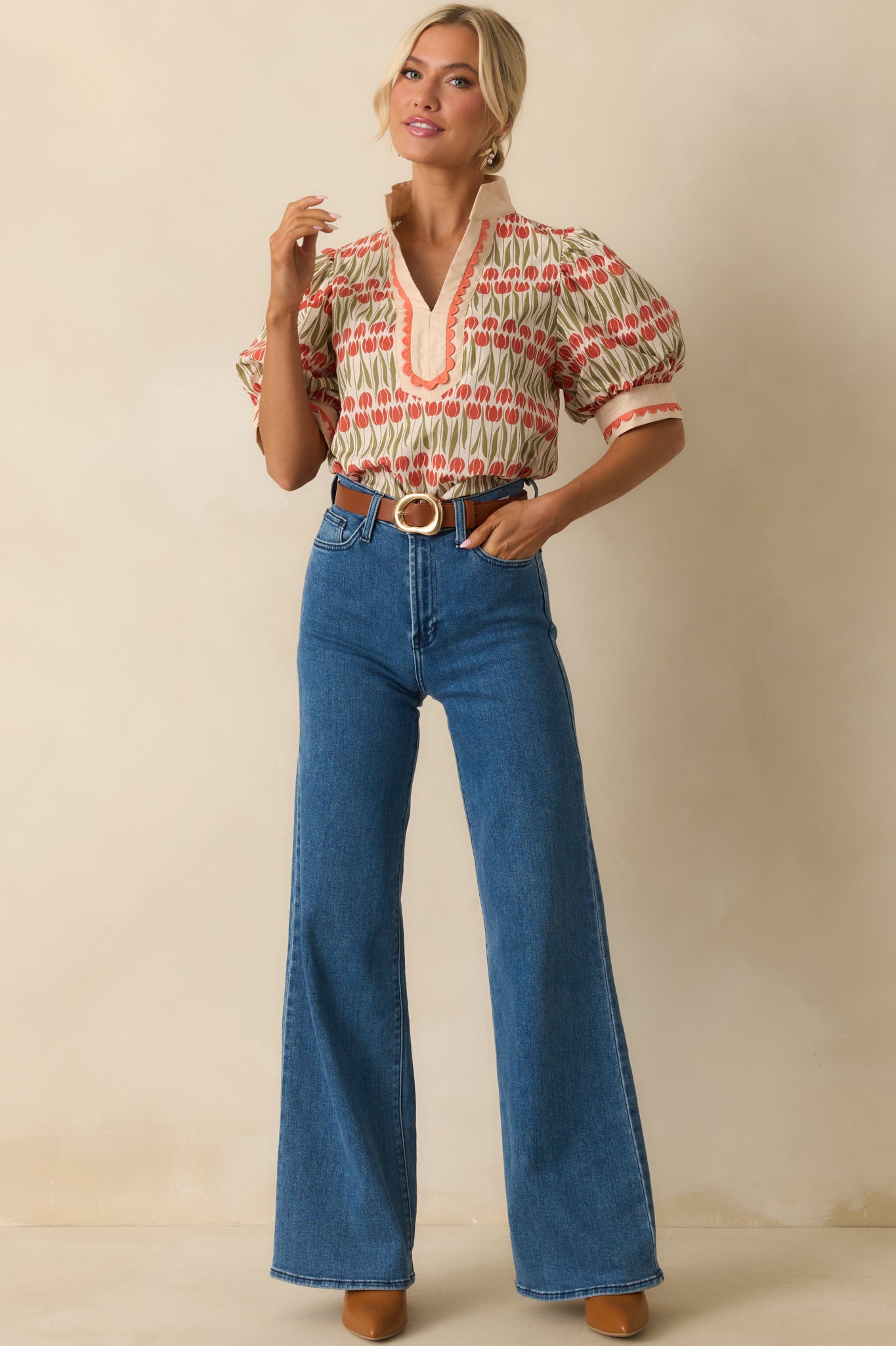 Floral ivory top with a split v-neckline framed by contrast scalloped edging and a straight hemline.