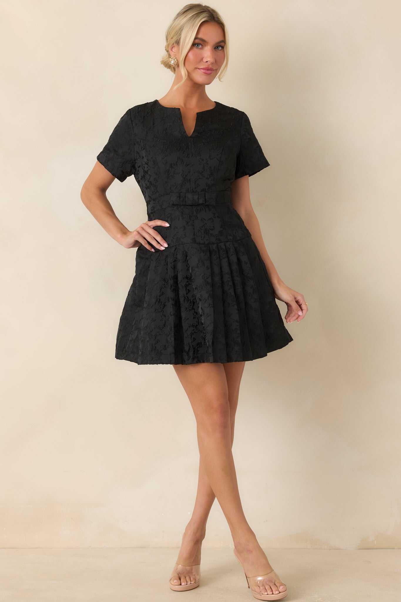Floral jacquard dress showcasing princess seams, defined waistband, petite bow detail, and feminine silhouette.