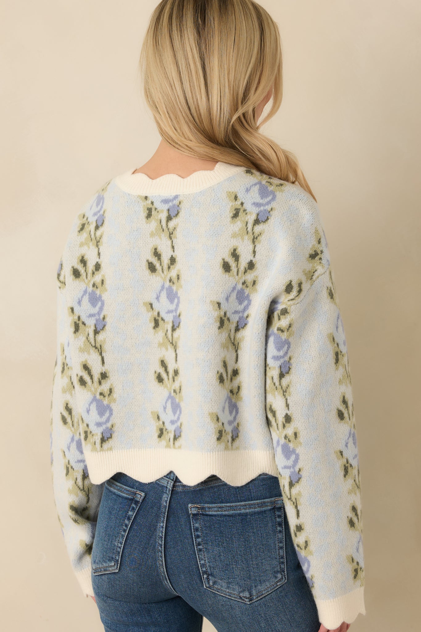 Blue floral knit sweater with long sleeves and a relaxed, slightly cropped silhouette from the rear.