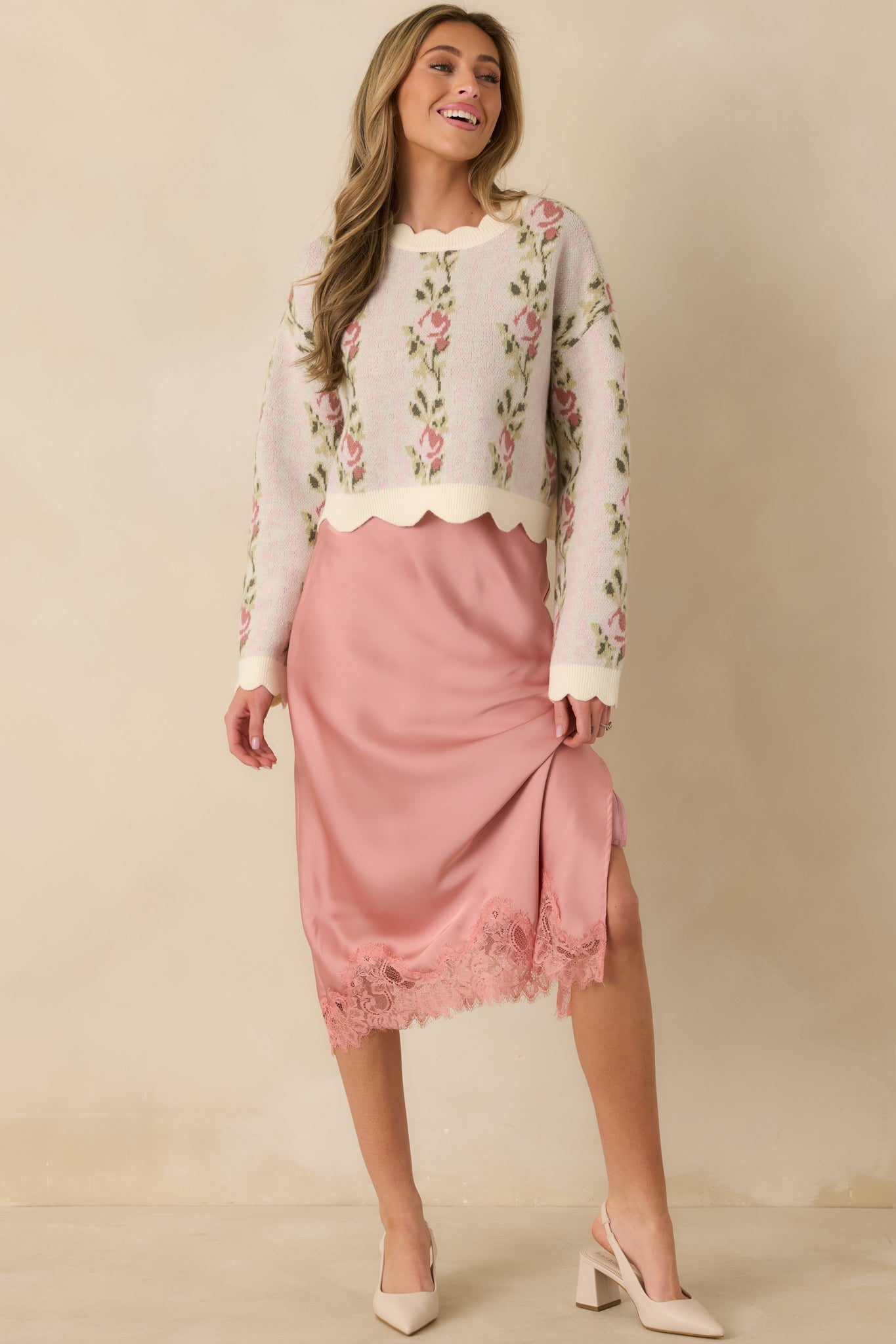 Pink floral knit top designed with scalloped cuffs, cozy texture, and an easy silhouette.