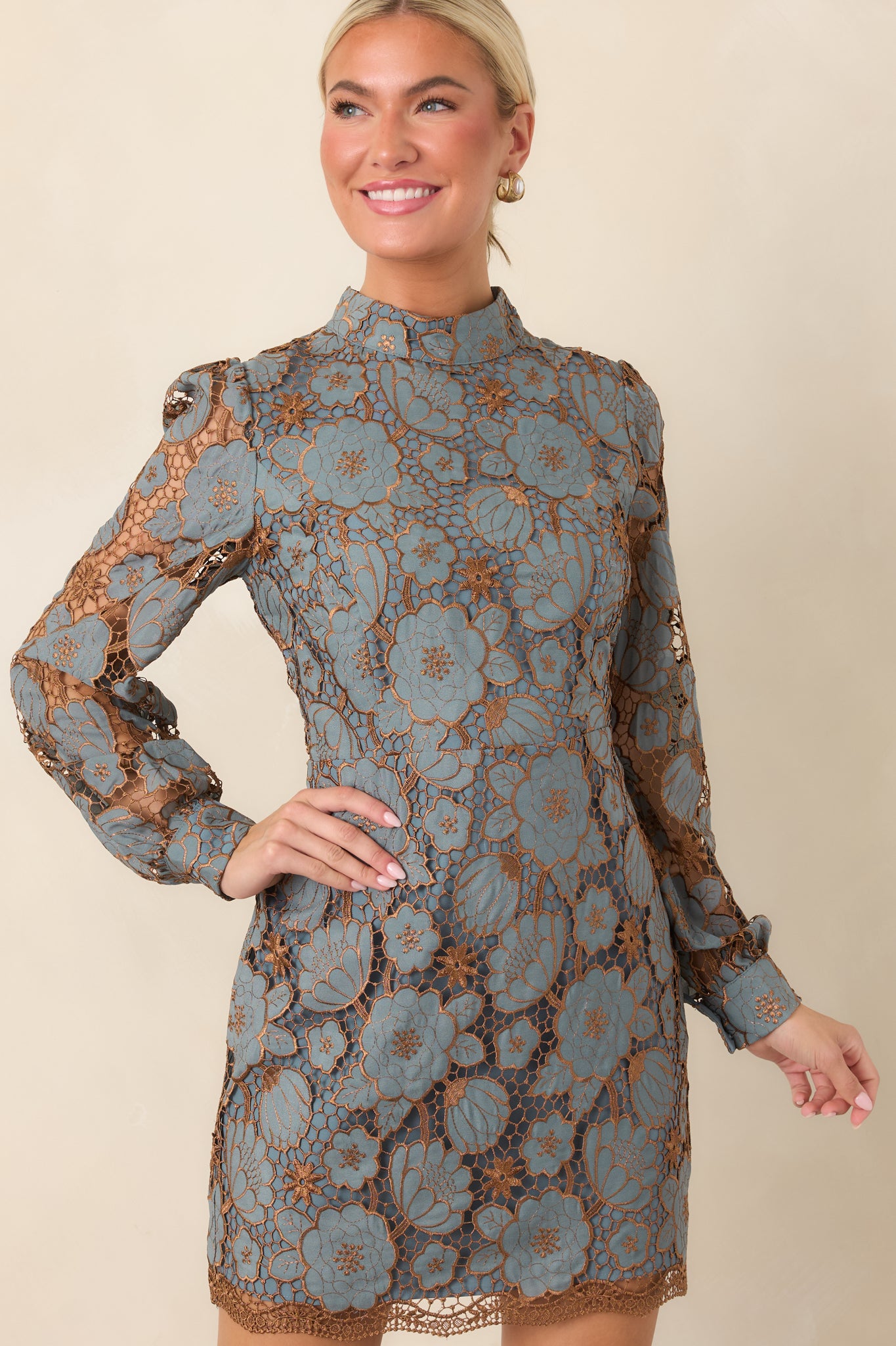 Close view of the mini dress highlighting its delicate floral lace overlay and shimmering bronze-toned botanical accents.
