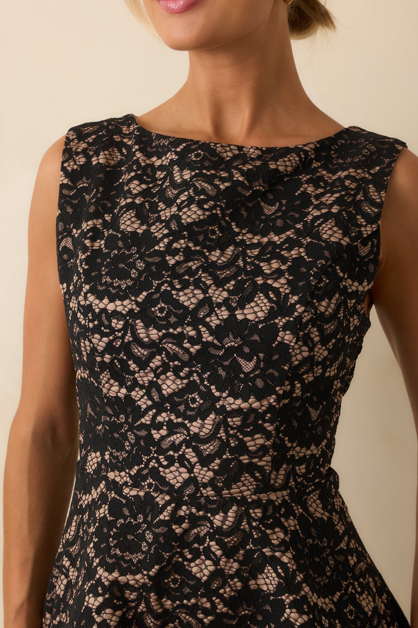 Detailed view of the floral lace overlay highlighting the intricate pattern and tan lining beneath.