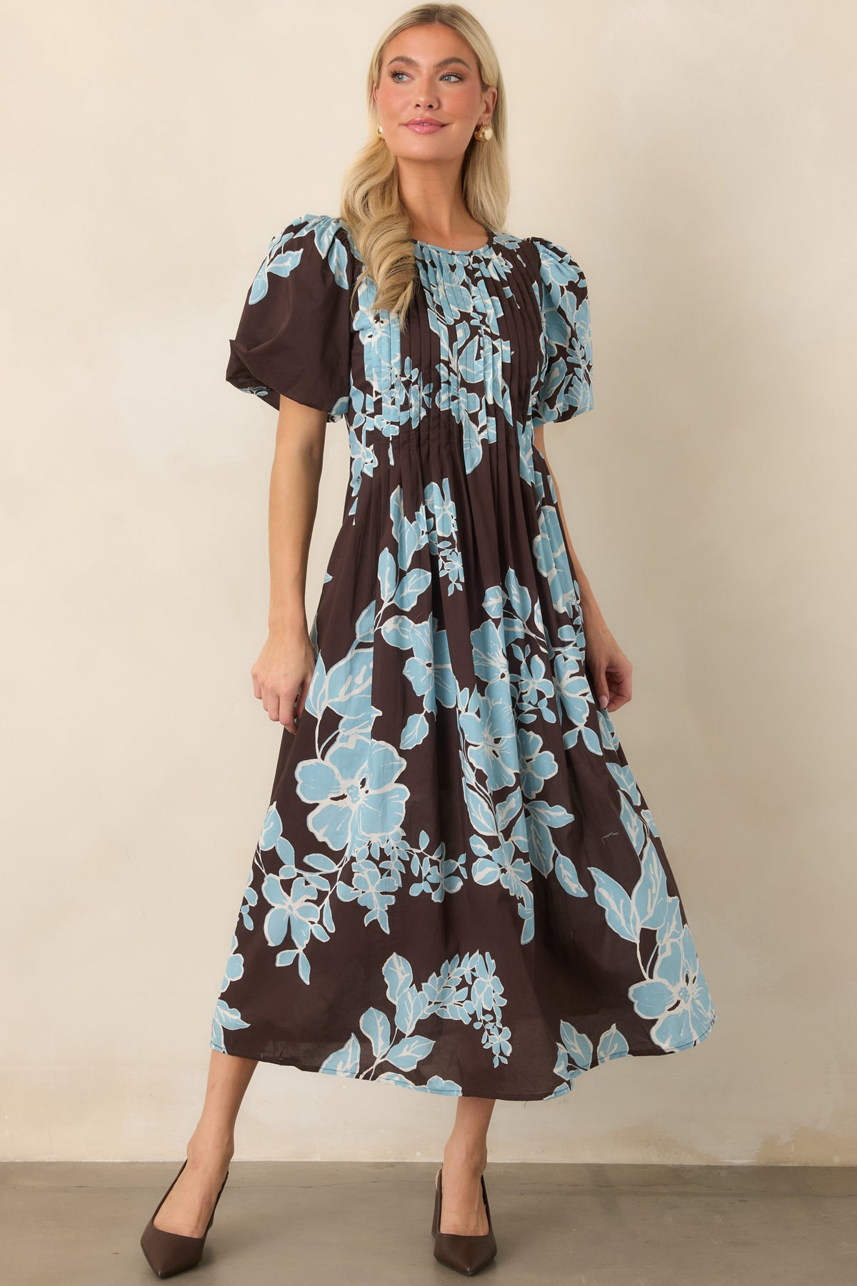 Floral dress featuring oversized light blue blooms, romantic short sleeves, and a smooth lined midi skirt.