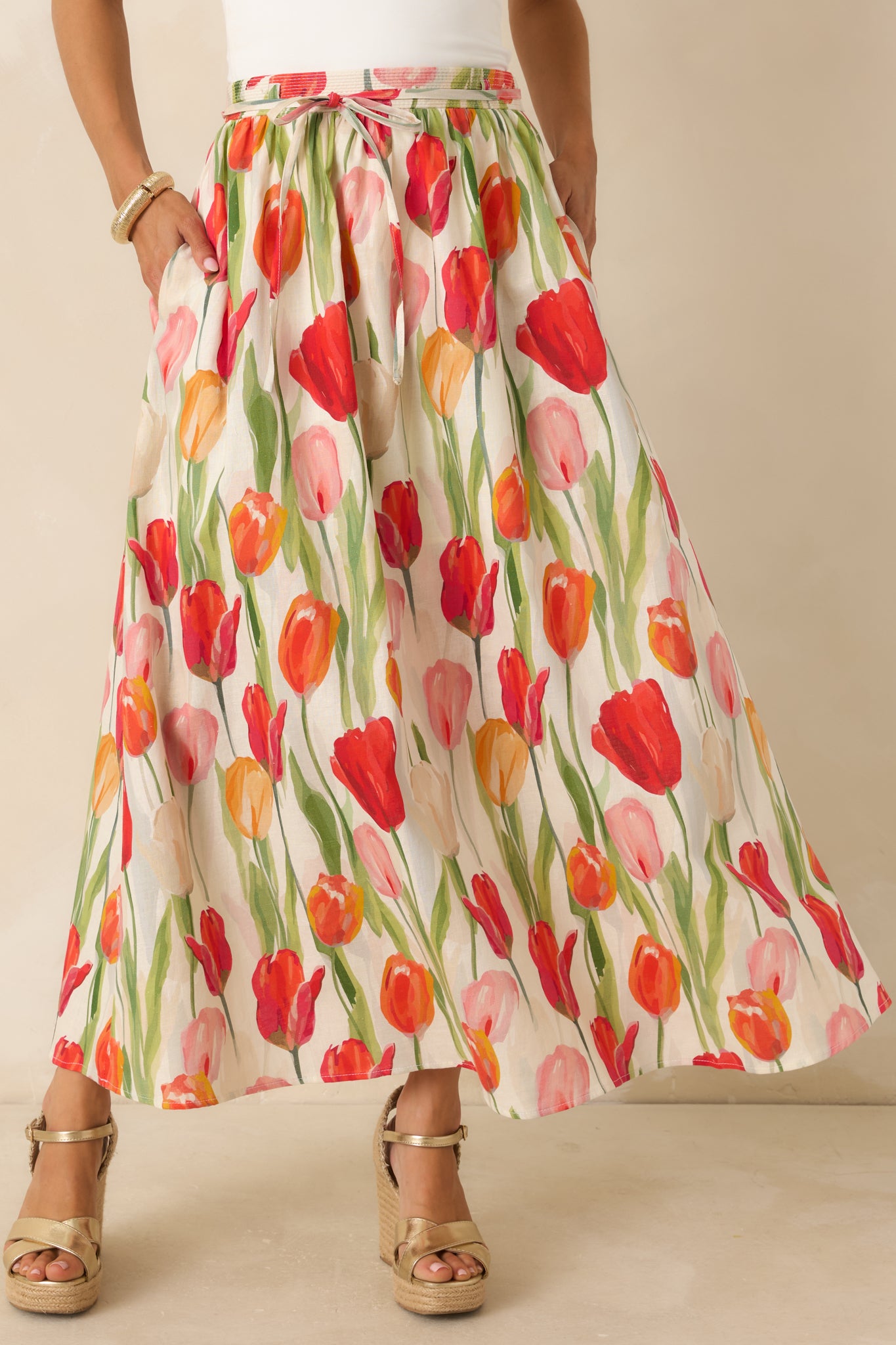Floral linen blend midi skirt featuring hidden side pockets, a colorful tulip print, and a breezy flowy shape.