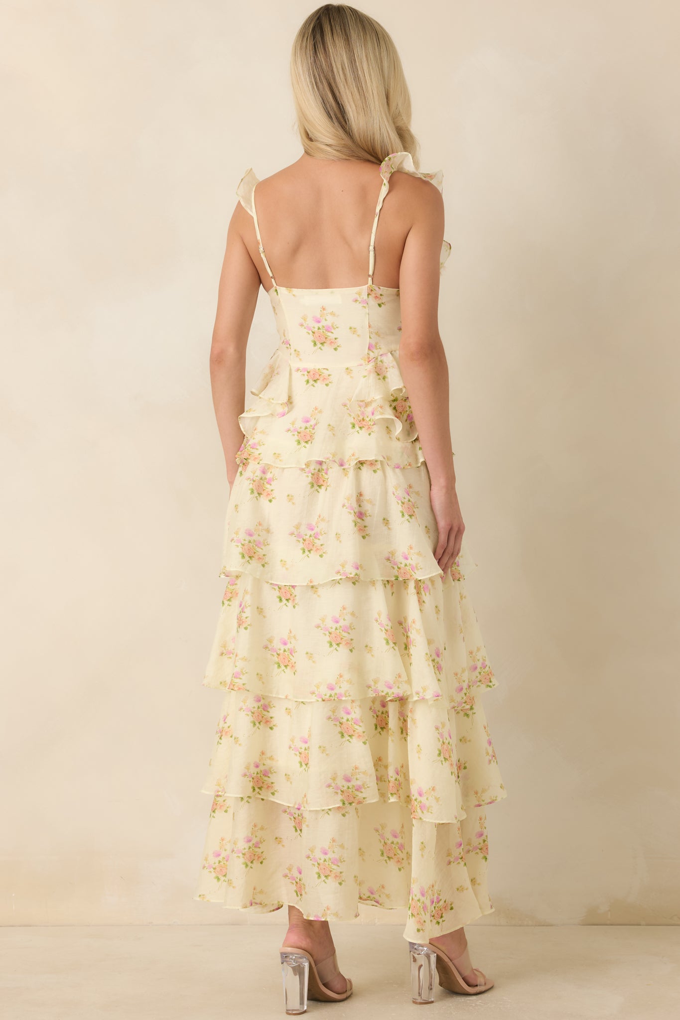 Back view of the floral maxi dress featuring adjustable spaghetti straps and a flowing tiered skirt.