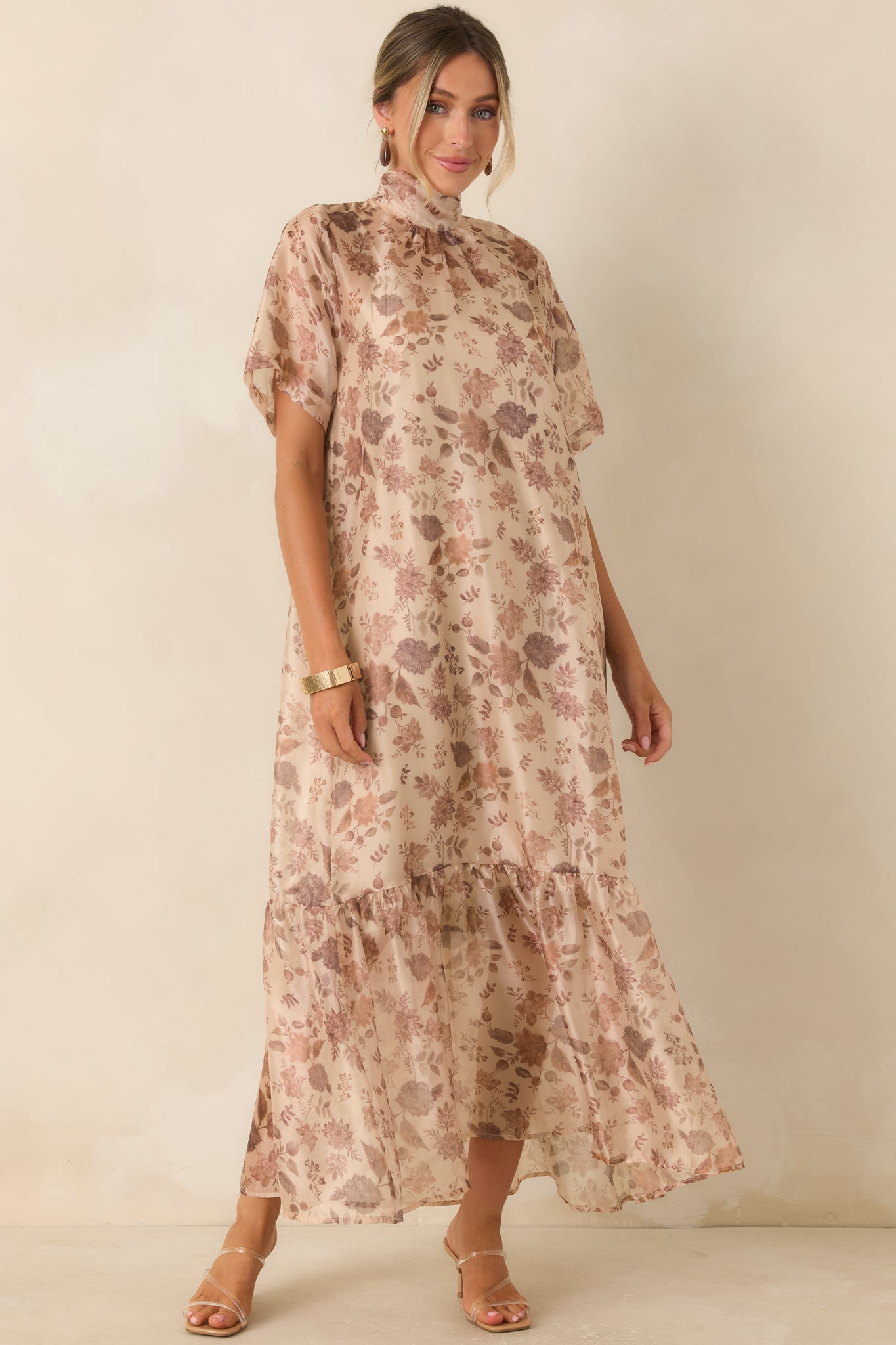 Floral maxi dress featuring a sheer printed overlay, fully lined slip, mock neckline, and flowing A-line silhouette with tiered hem.