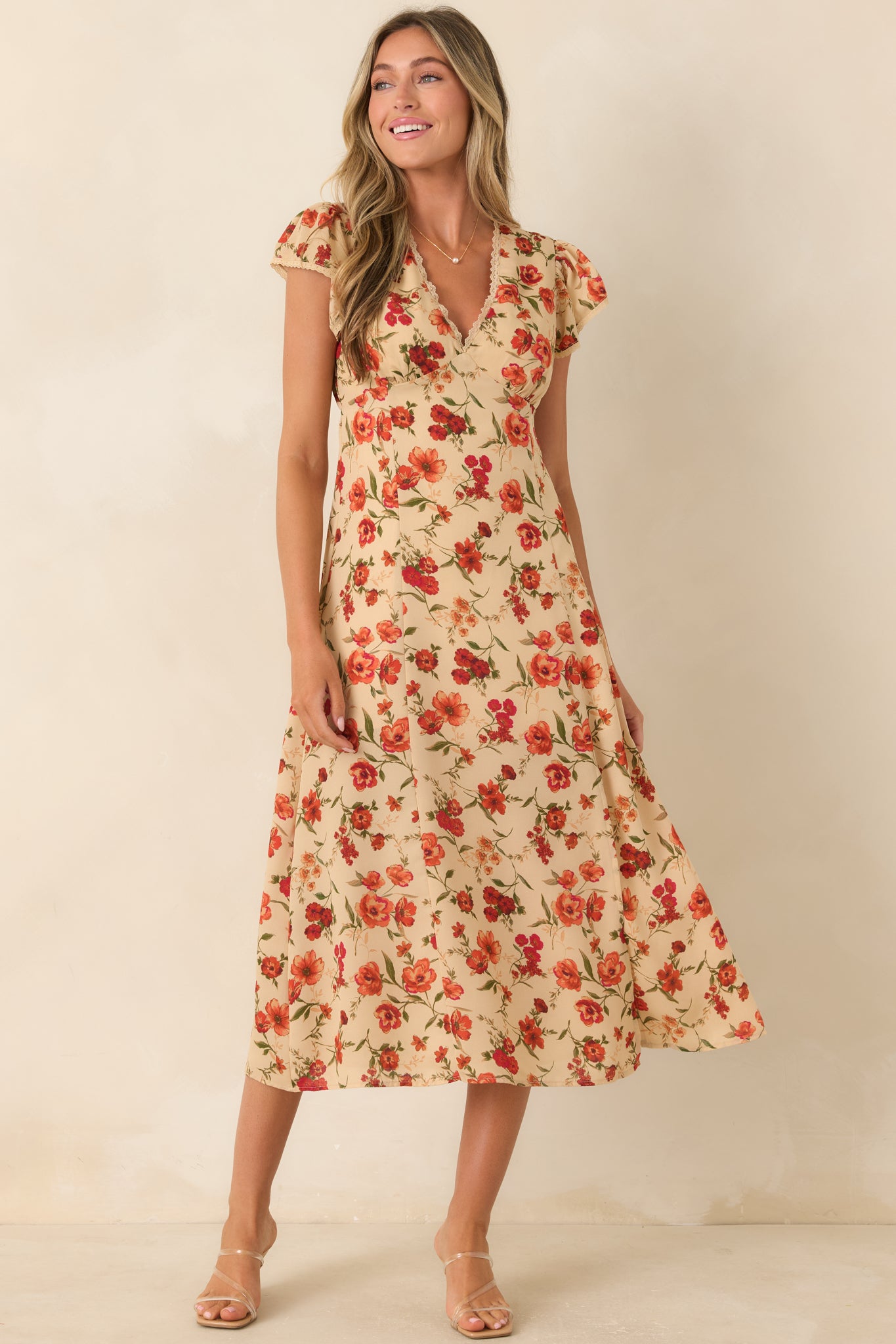 Floral midi dress featuring a surplice V-neckline with lace trim, empire waist, short flutter sleeves, and an adjustable back tie.