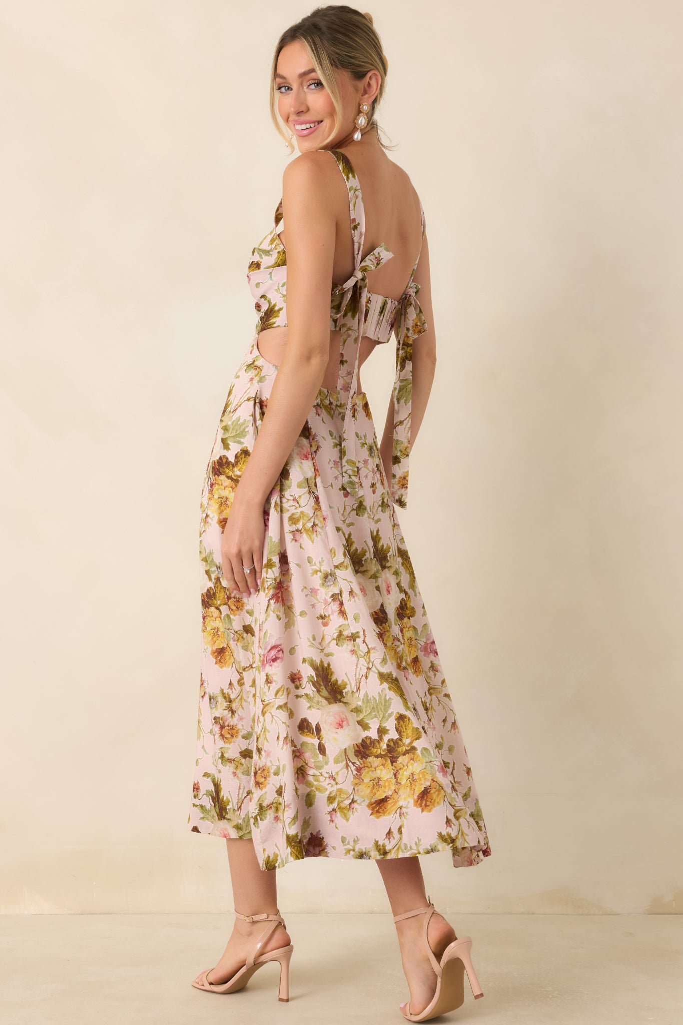 Rear view of the floral midi dress highlighting the open back design, self-tie shoulder straps, and flowing A-line skirt.