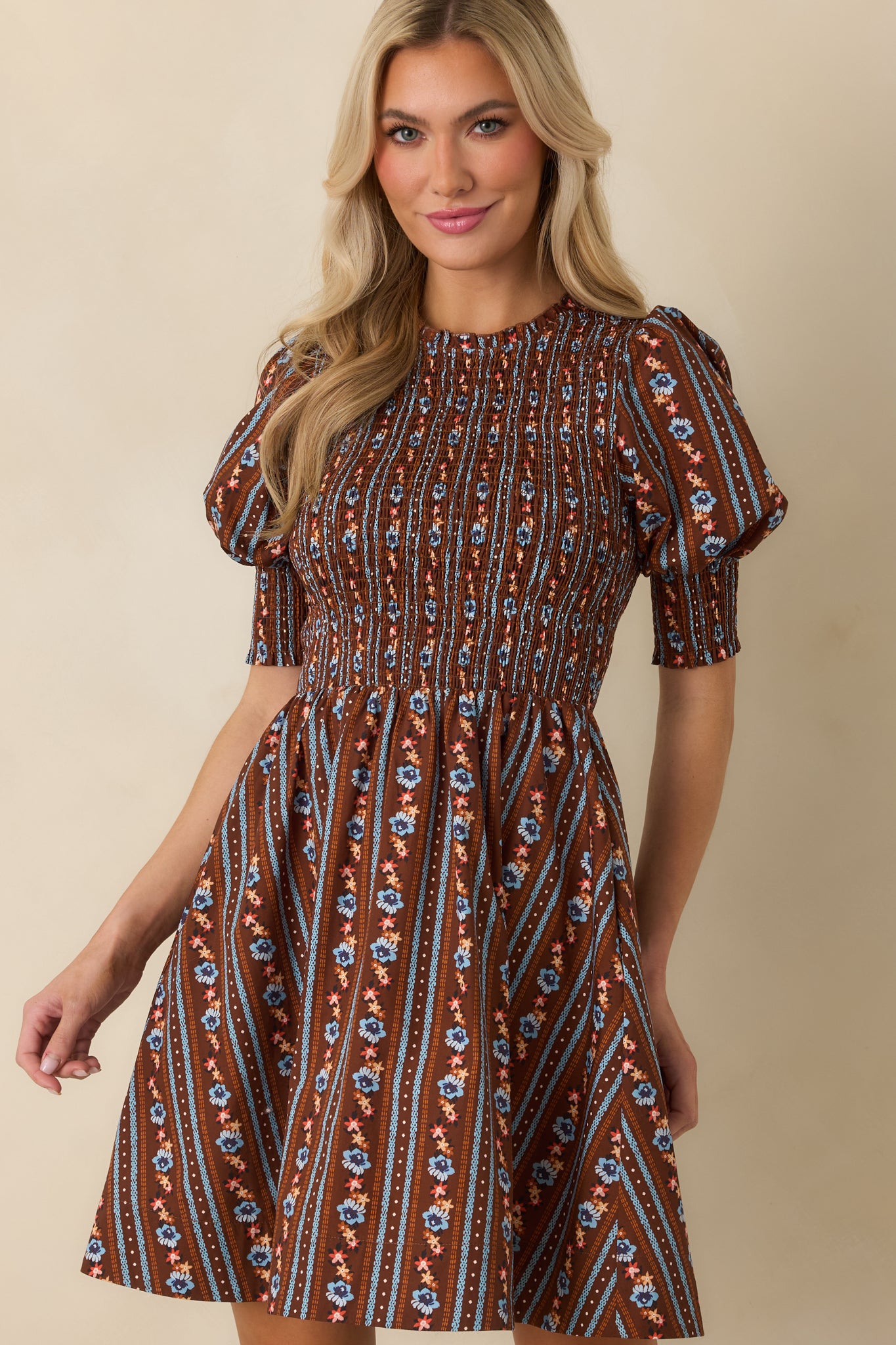 Floral mini dress highlighting the removable tie belt and comfortably smocked waist before the skirt flares outward.