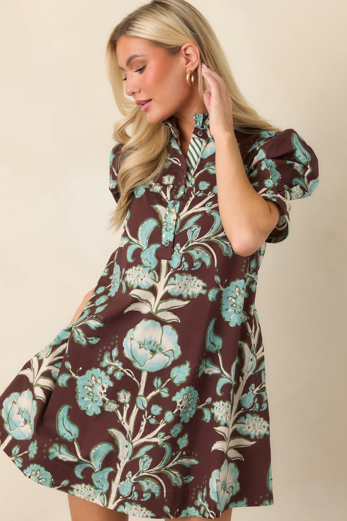 Button-front placket runs through the colorful floral print, complemented by the dress's ruffled stand collar and relaxed shape.