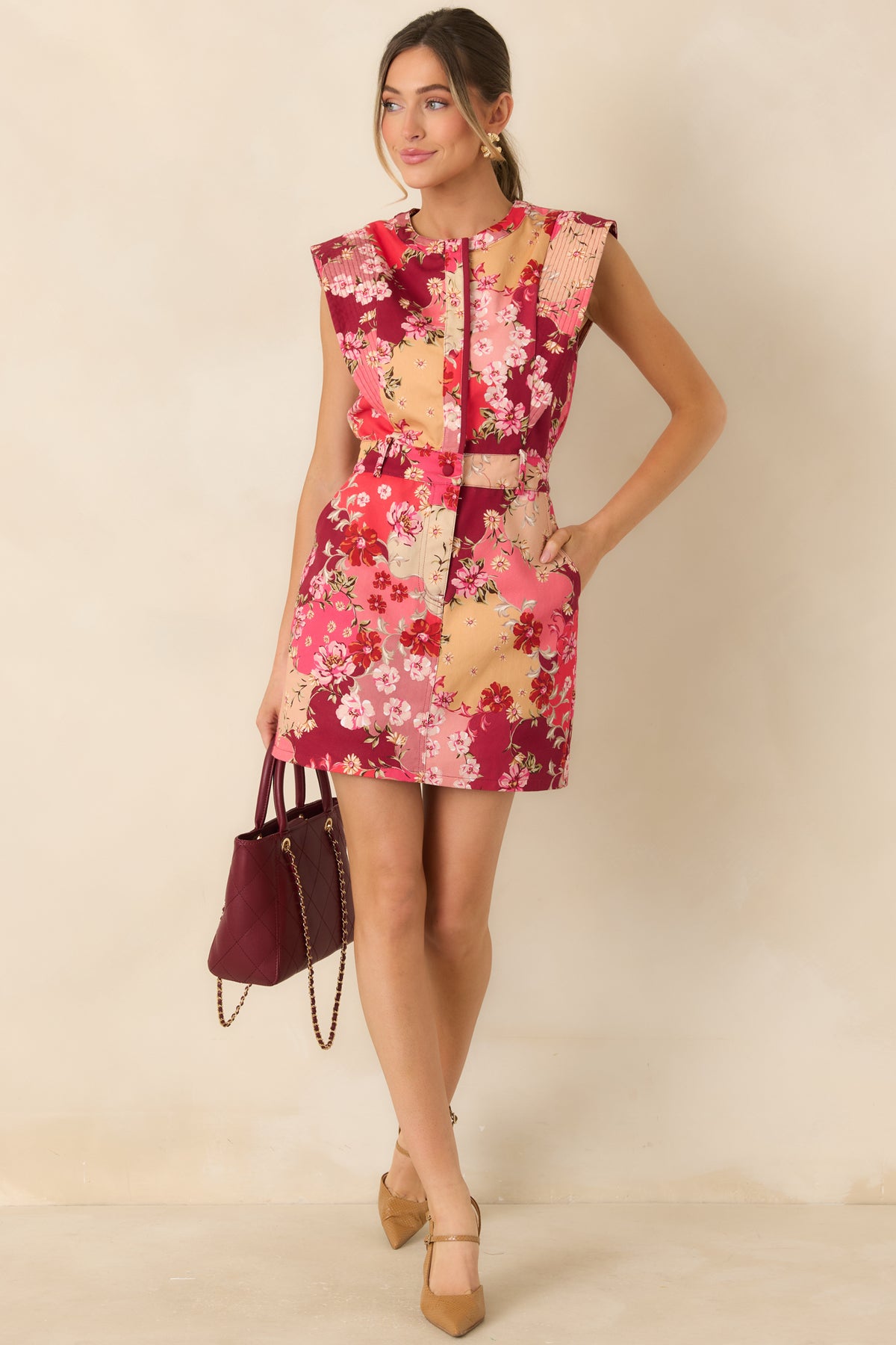 Colorful floral mini dress featuring wide stitched shoulder panels, a defined waistband, and a short flared skirt.